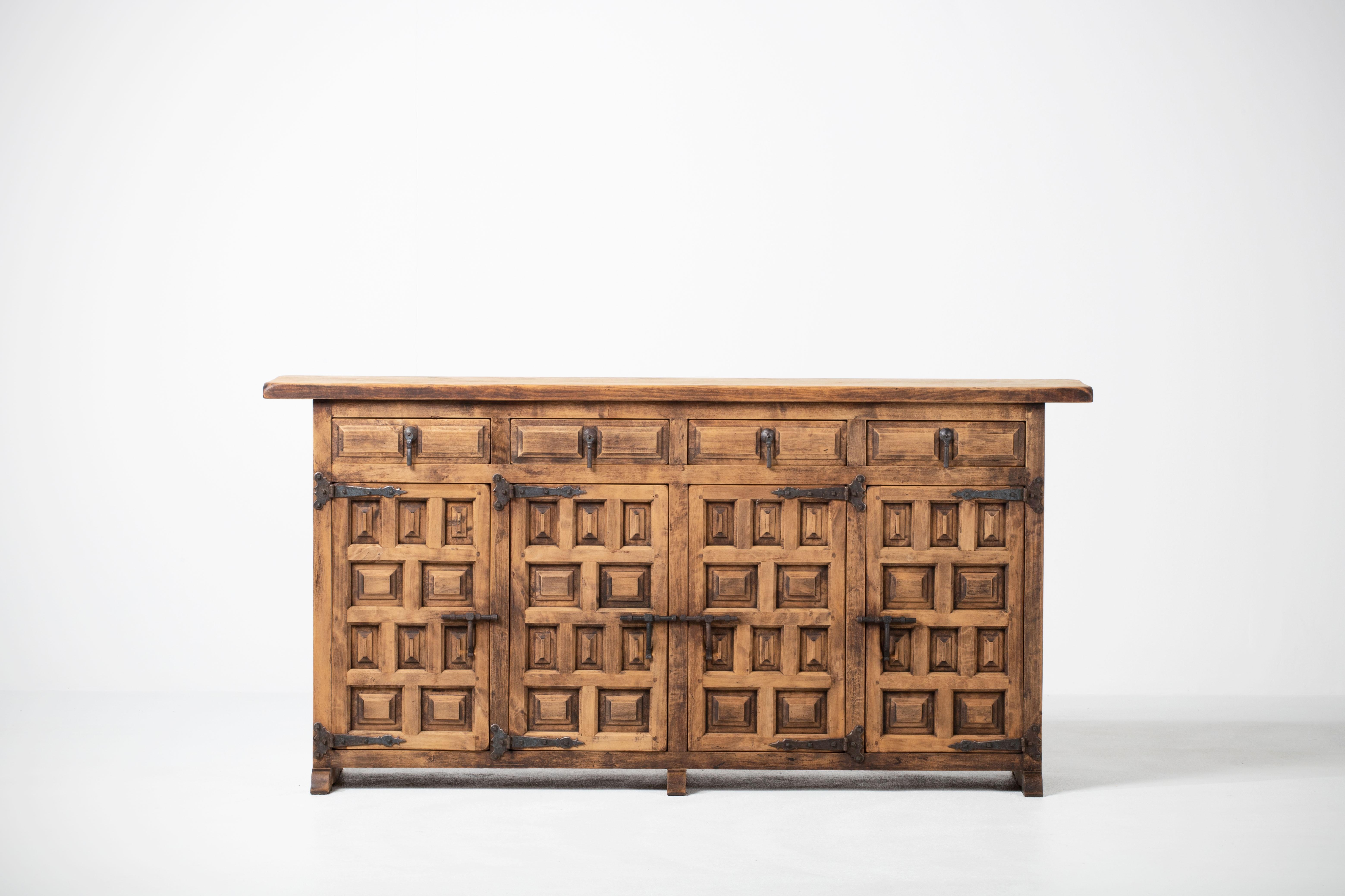 From Northern Spain, constructed of solid walnut, the rectangular top with molded edge a top a conforming case housing four drawers over four doors, the doors paneled with solid walnut, raised on a plinth base.
     