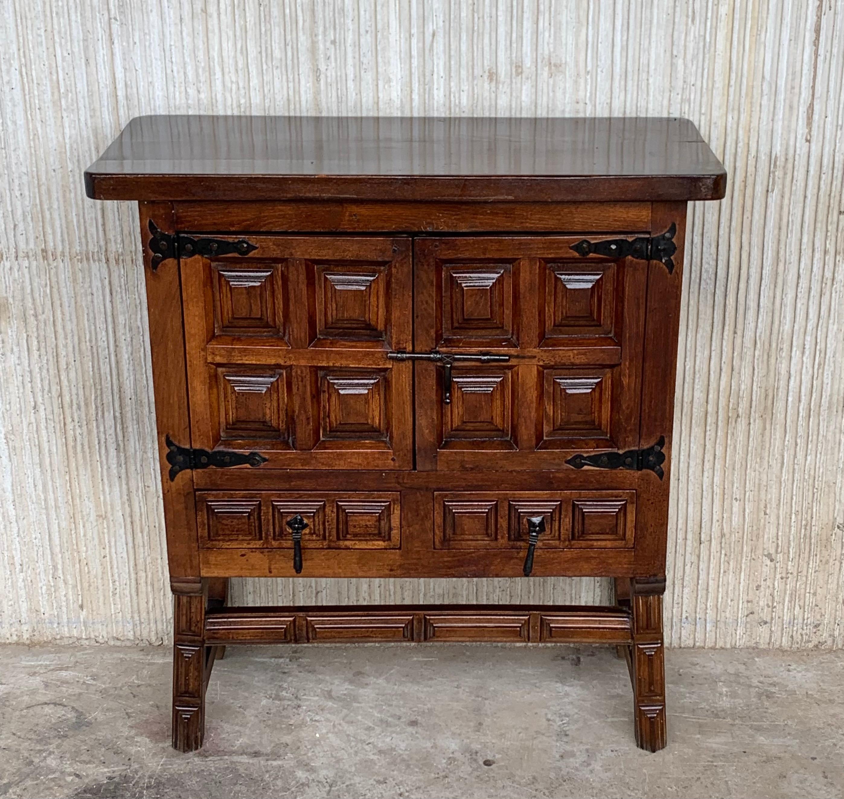 From Northern Spain, constructed of solid walnut, the rectangular top with molded edge atop a conforming case housing two doors paneled with solid walnut, two drawers on the low part and raised on four round legs.
Carved on the molding sides of the