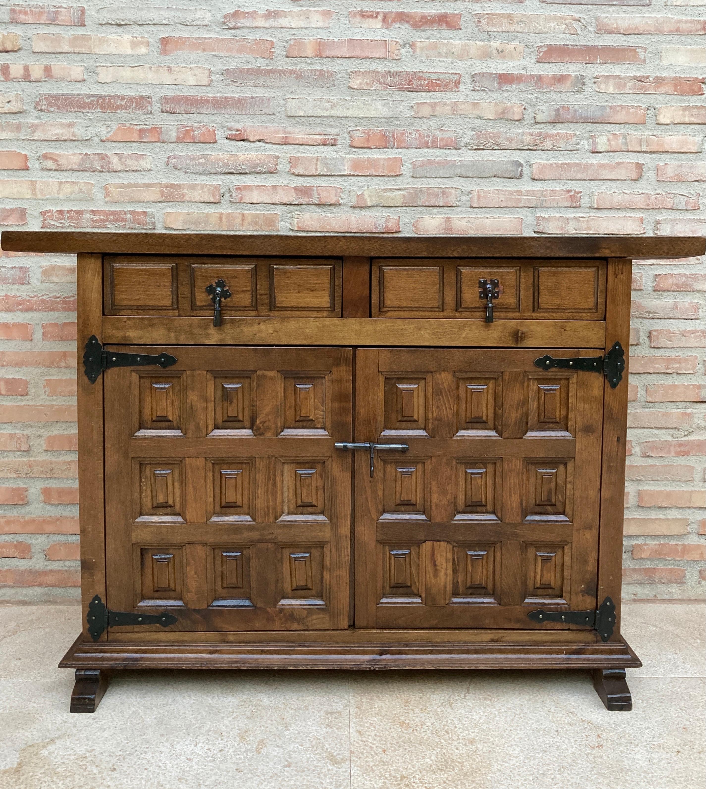 From Northern Spain, constructed of solid walnut, the rectangular top with molded edge atop a conforming case housing two drawers over two doors, the doors paneled with solid walnut, raised on a plinth base.

Condition report:

This vintage item