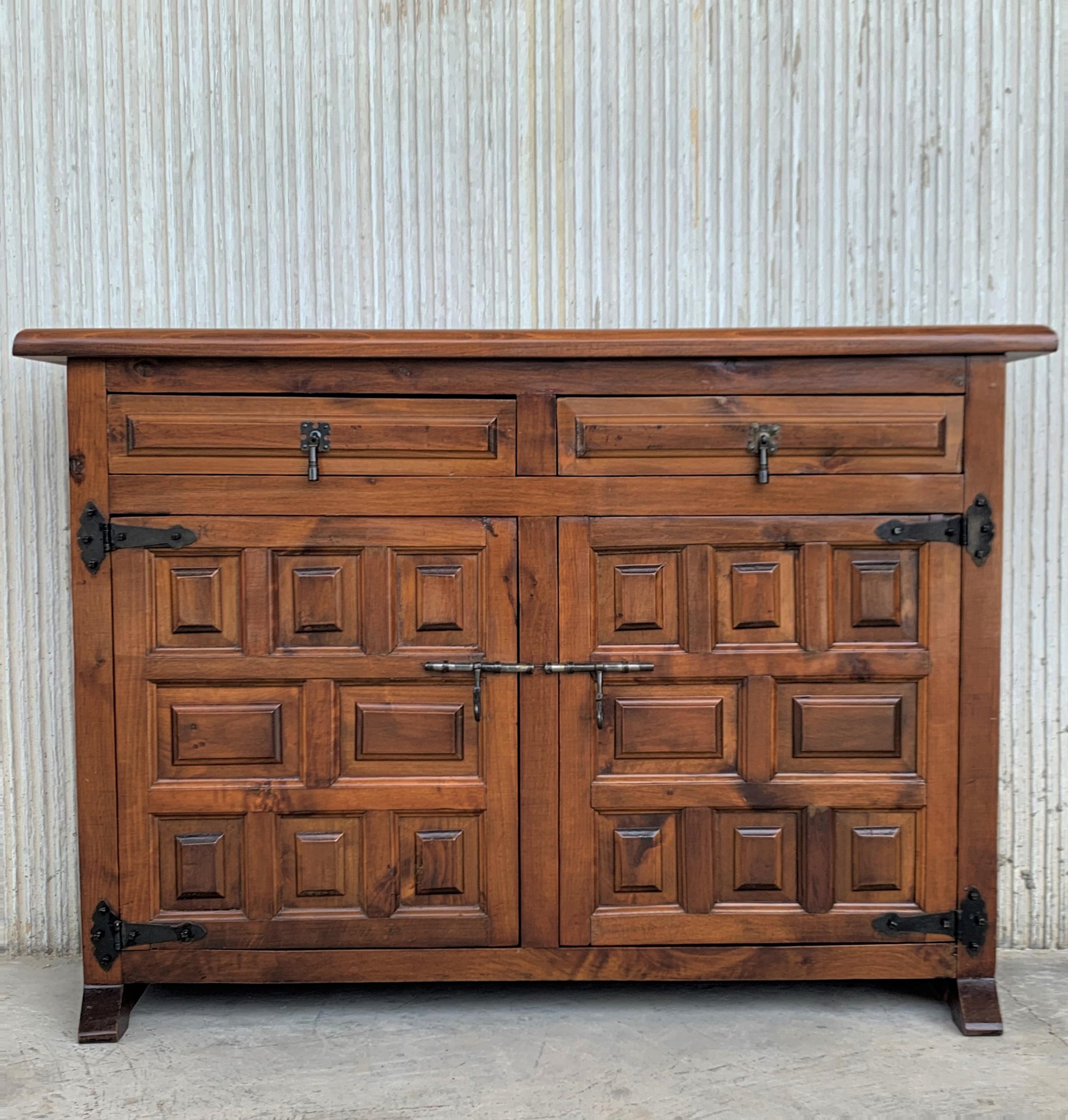 From Northern Spain, constructed of solid walnut, the rectangular top with molded edge atop a conforming case housing two drawers over two doors, the doors panelled with solid walnut, raised on a plinth base.

  