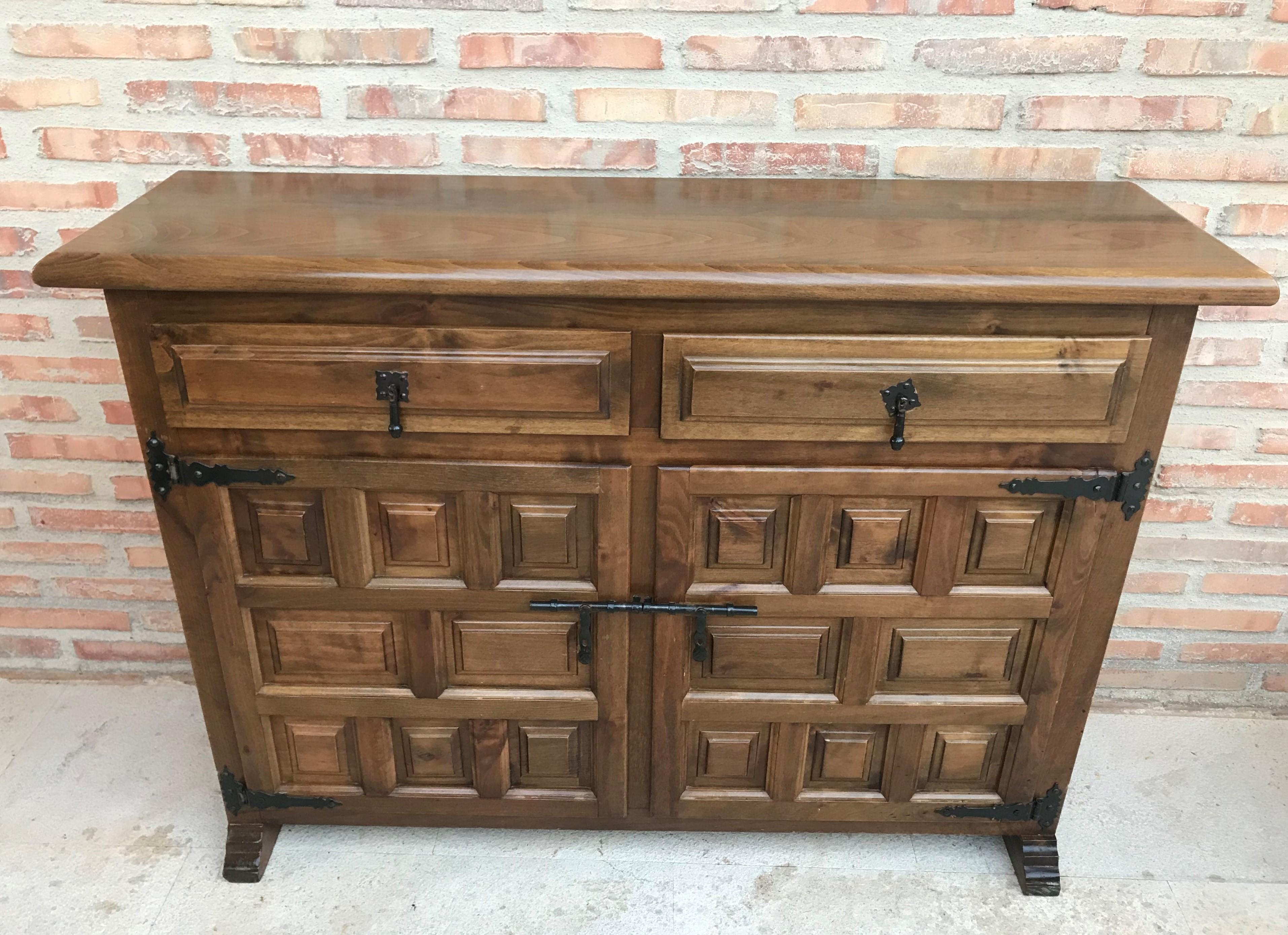 From Northern Spain, constructed of solid walnut, the rectangular top with molded edge atop a conforming case housing two drawers over two doors, the doors panelled with solid walnut, raised on a plinth base.

  