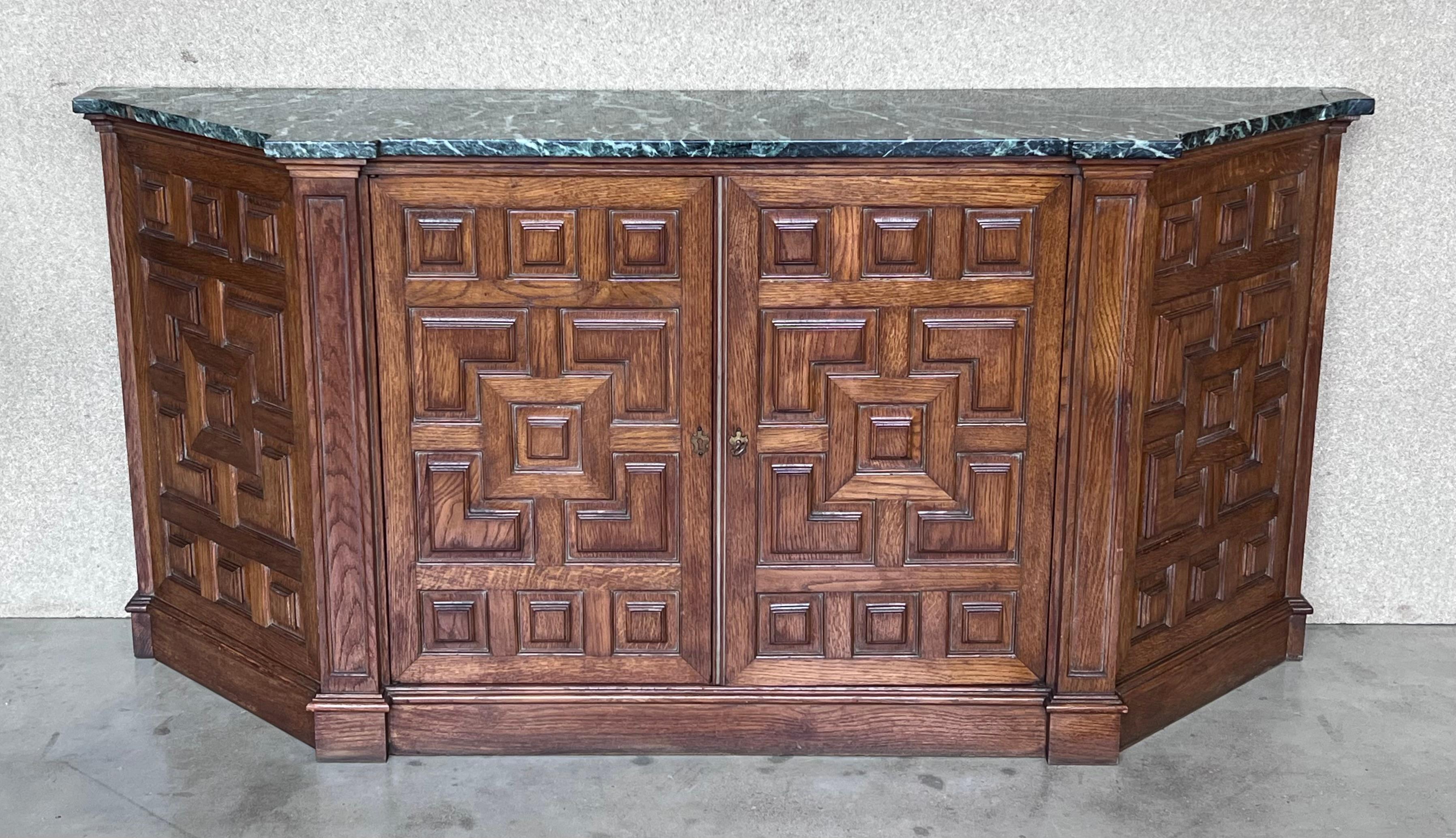 From Northern Spain, constructed of solid walnut, the rectangular top with molded edge atop a conforming case housing two doors paneled with solid walnut, raised on a plinth base.
  It has a green marble.