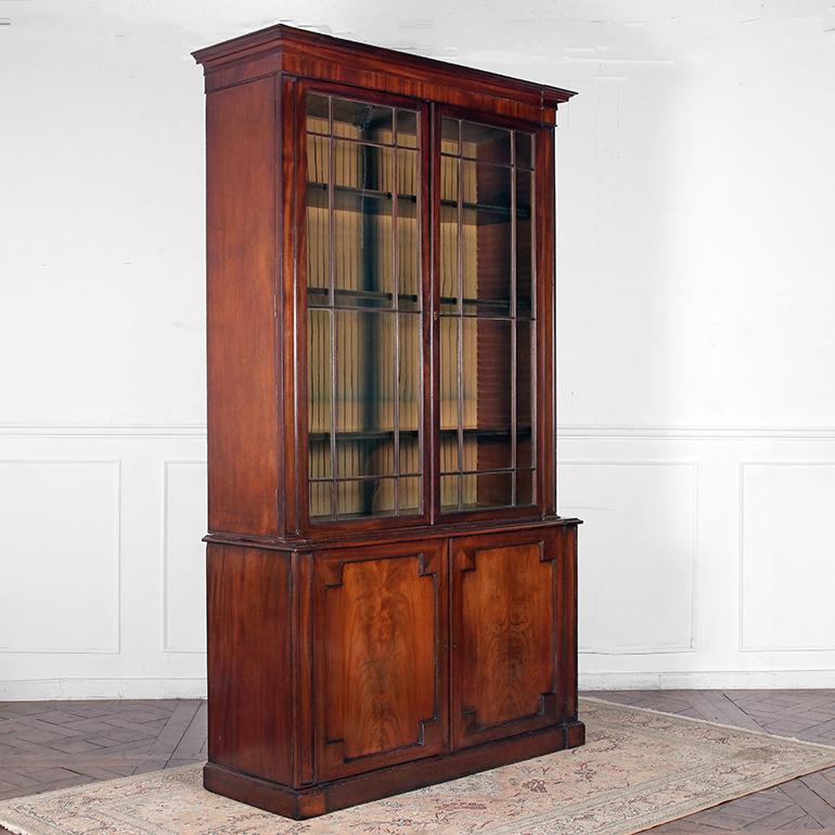 A 19th Century mahogany Glazed Bookcase having a moulded cornice above a pair of large glazed doors enclosing three adjustable shelves, with the original folded silk back lining. The lower half is comprised of a fitted pair of panel doors enclosing