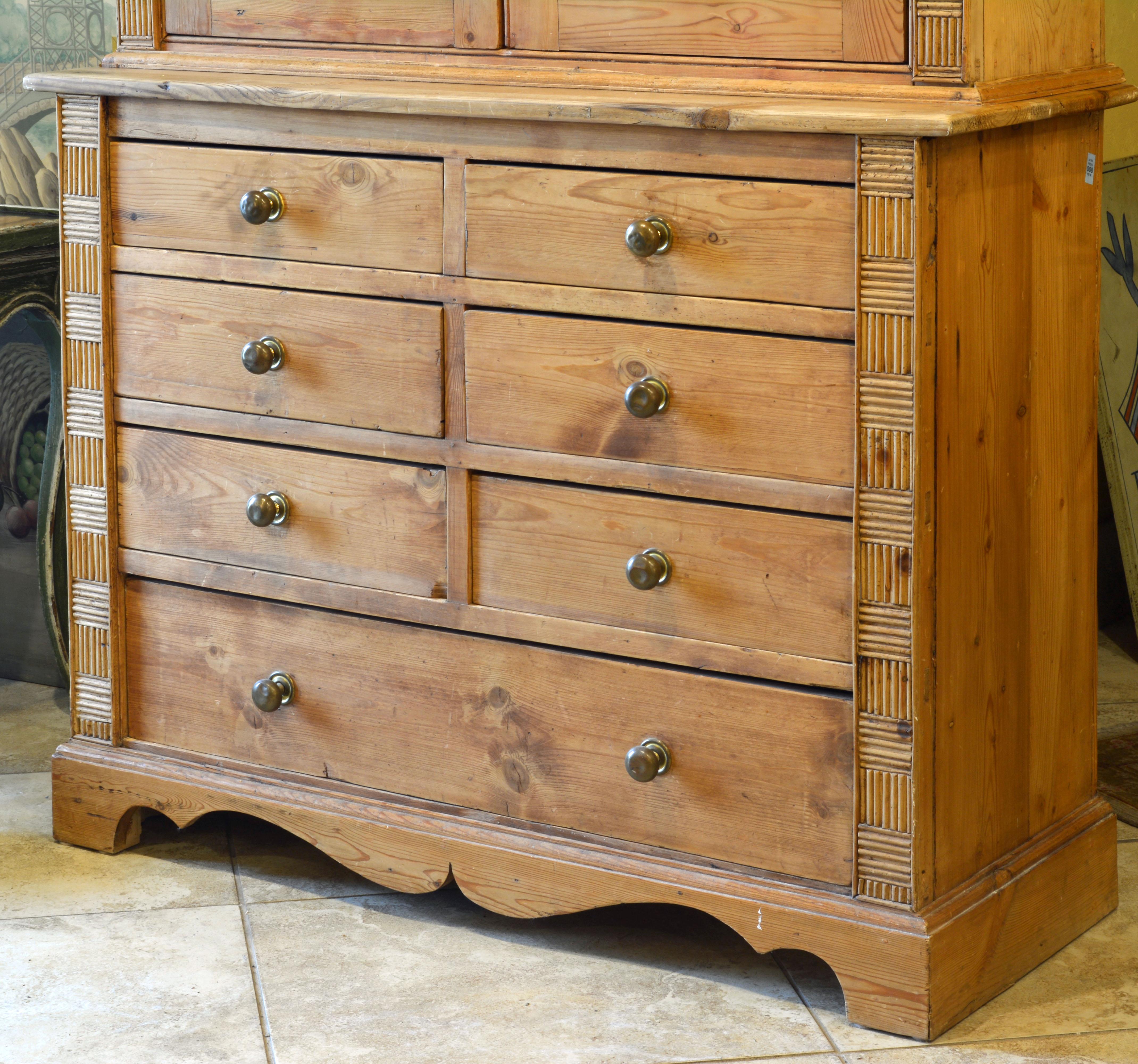This 19th century English two-part pine step back cupboard or buffet features an upper part with Georgian style glazed doors opening up to a shelved interior and flanked by panels of matchstick moulding mosaic. The bottom part features a unusual