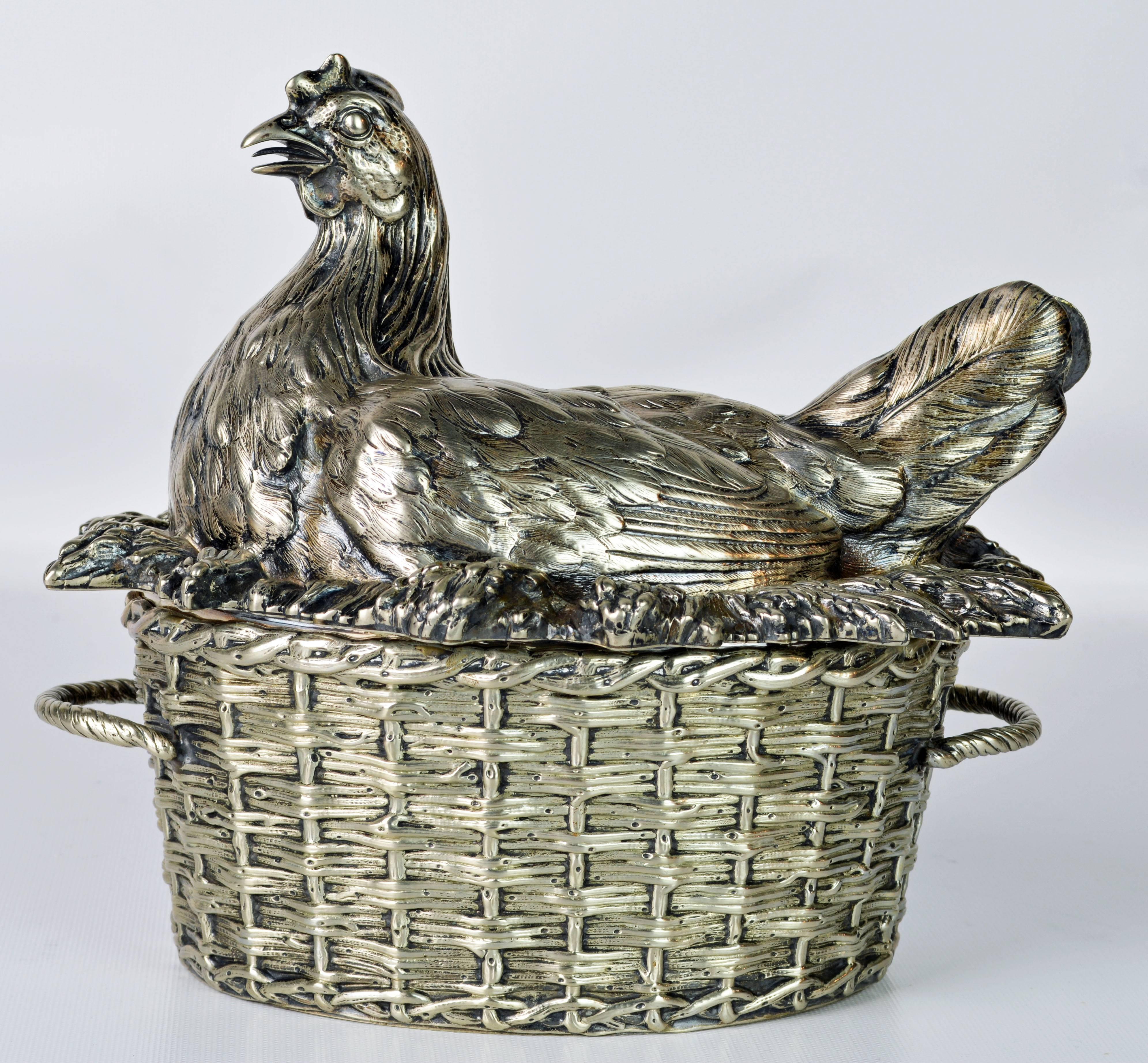 Of great sculptural and decorative quality this rare piece was made by well known silversmiths G. R Collis and Co. in Birmingham. It features a cover in the shape of a hen lying on her nest above the oval bowl in the shape of a handled basket with