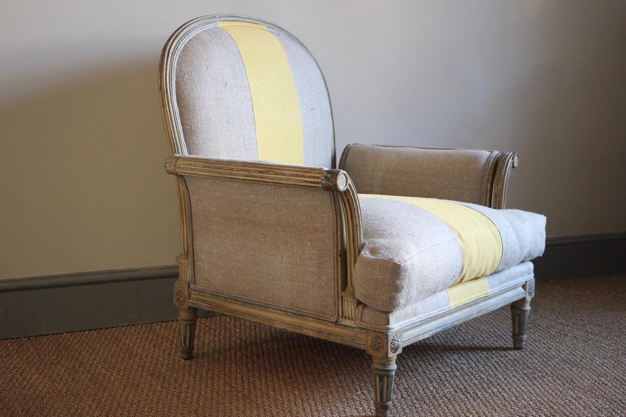 A wonderful 19th century French painted armchair of great scale and very unusual design, retaining the original paint, having been recently reupholstered by us in a neutral Irish linen and a 19th century hand dyed yellow linen. 
This elegant, yet