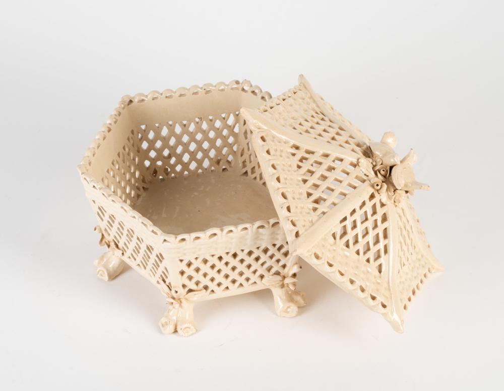A 19th century vintage creamware basket in hexagonal form with an openwork pattern and lid surmounted by elegant doves.

Approximate Size: 11.5” x 8.25” (h)

Creamware was popular in Europe during the mid-19th century and was produced by various
