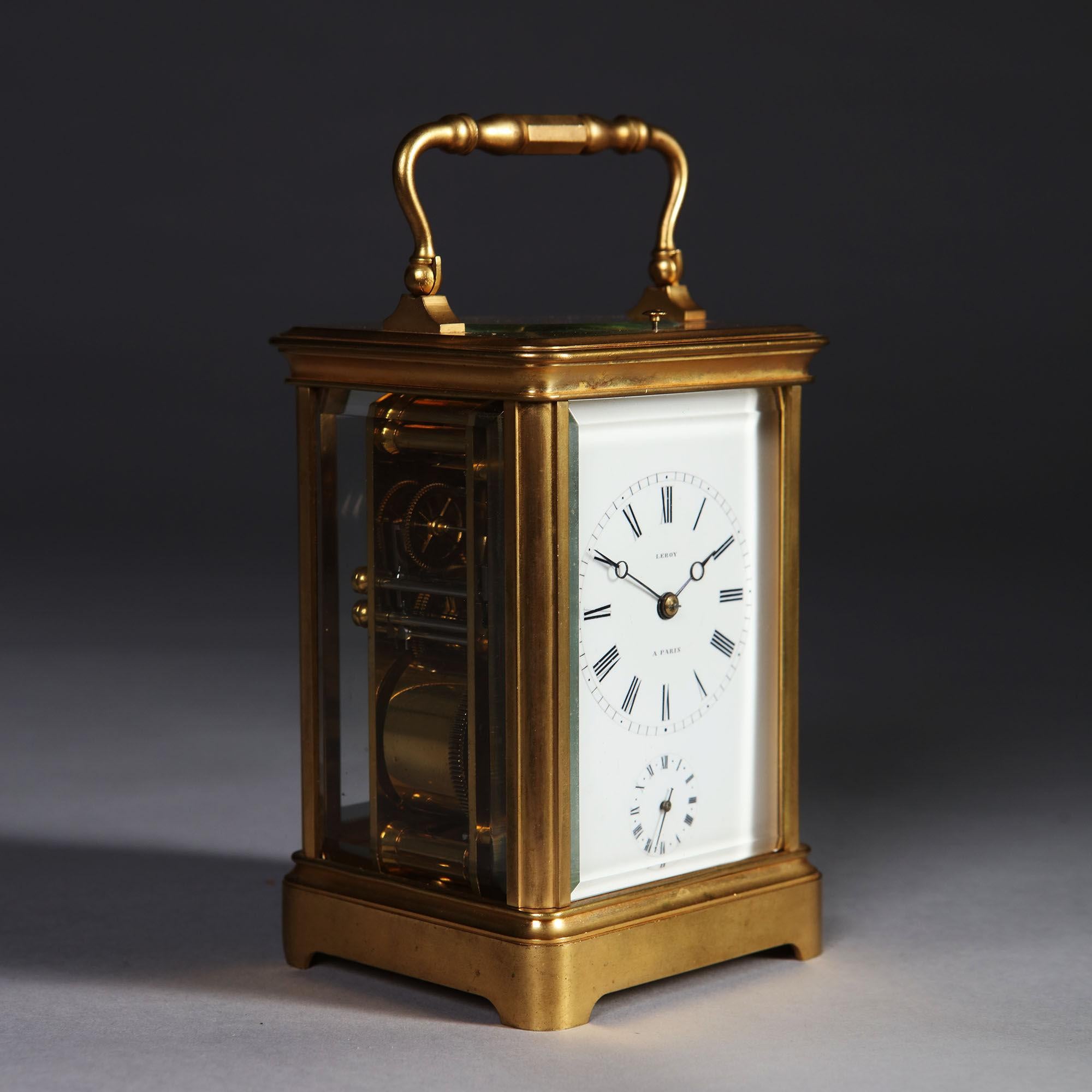 The gilt-brass, so-called corniche case has bevelled glass panels on all sides so that the movement is entirely visible. It is surmounted by a shaped carrying handle. The white enamel dial has a Roman chapter ring, with Arabic five-minute and minute