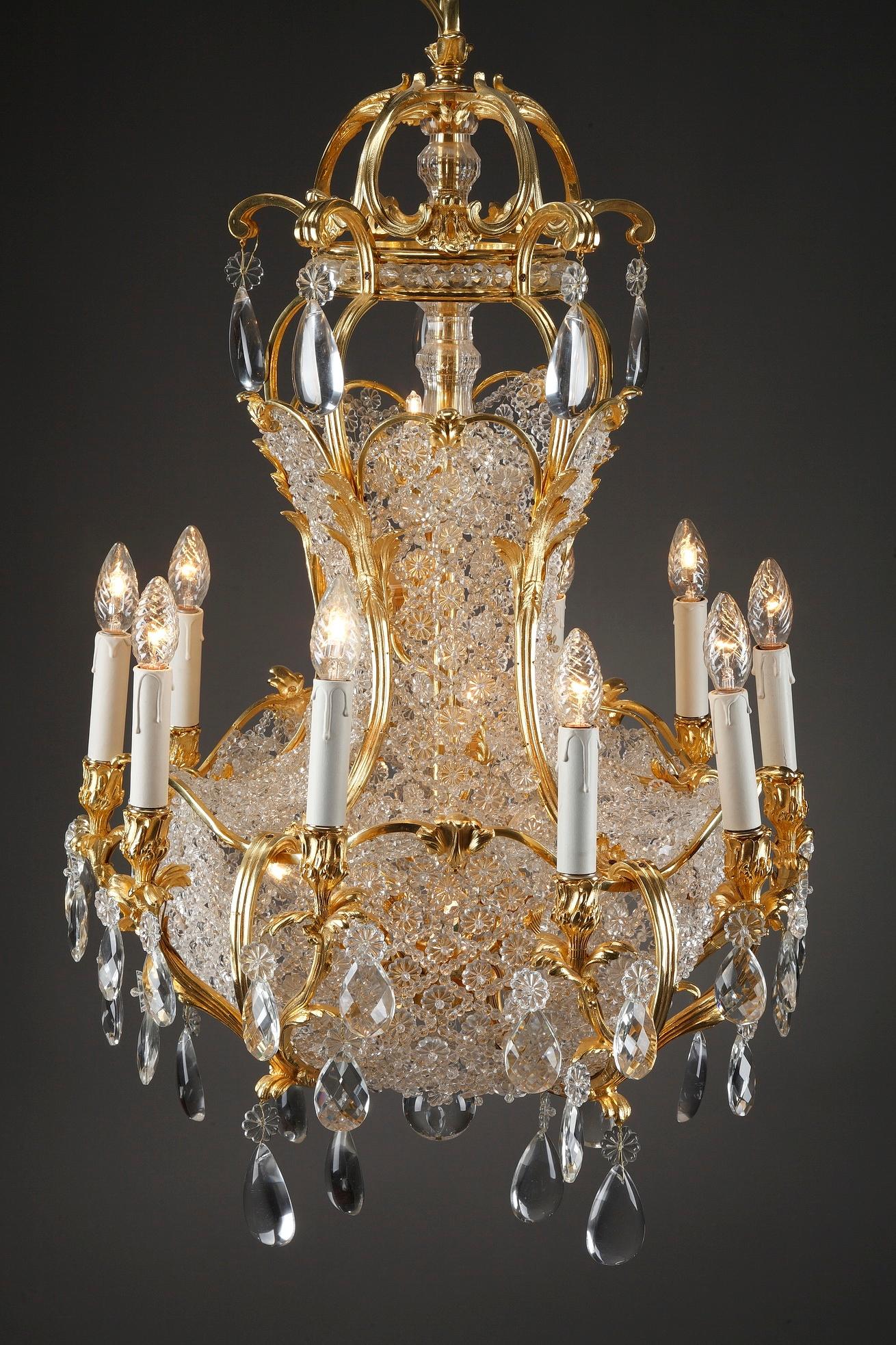 Monumental 10-light basket-shaped chandelier of gilt bronze and crystal, crafted in the late 19th century in France. Beautifully designed oversized prisms, rosette and slice-cut drops of polished crystal hang from scrolling ormolu branches. This