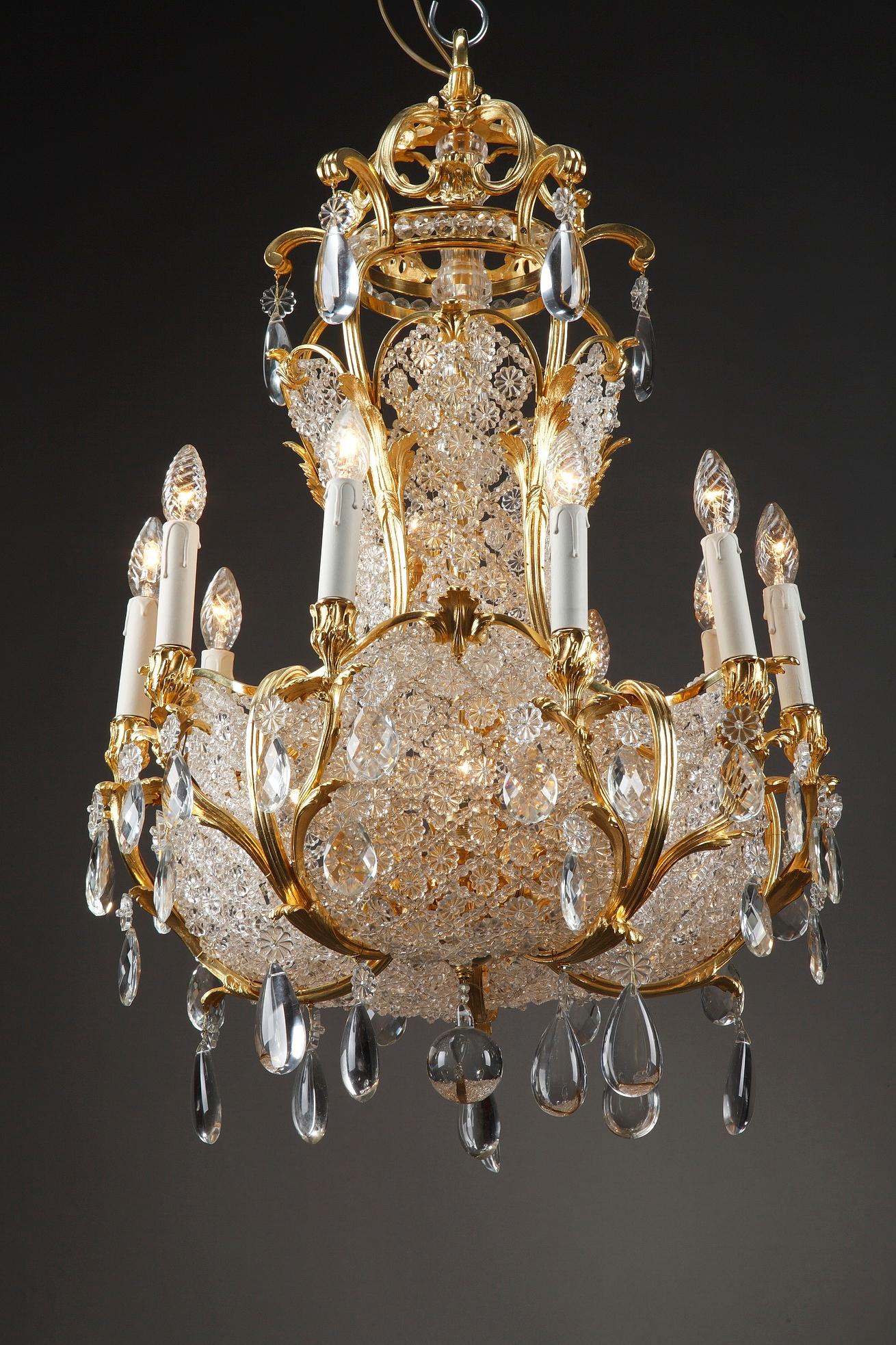 Monumentale lampadario a 10 luci a forma di cesto in bronzo dorato e cristallo, realizzato alla fine del XIX secolo in Francia. Prismi sovradimensionati, rosette e gocce tagliate a fettine di cristallo lucido sono appesi a rami di ormolu che