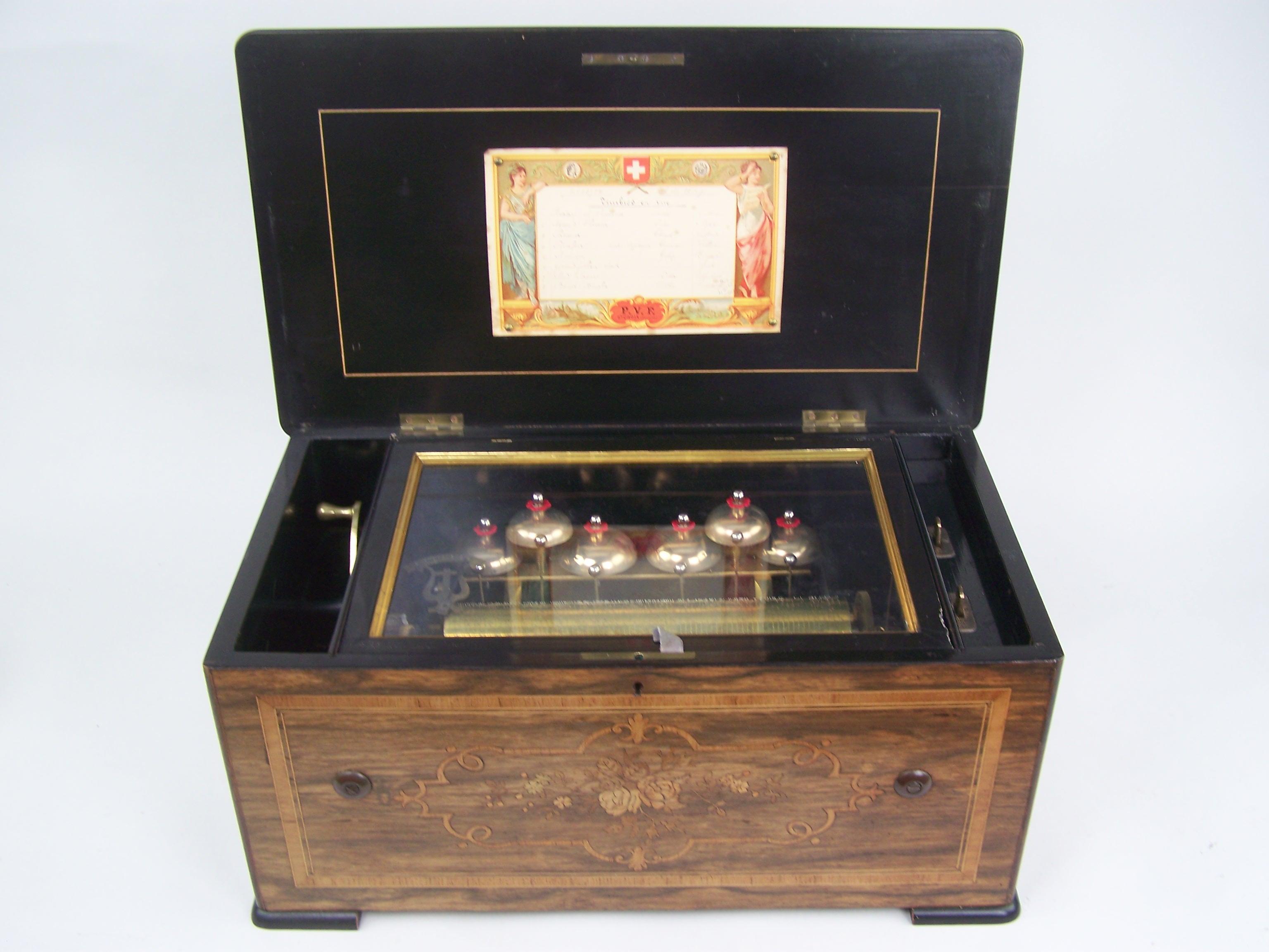Very beautiful bells in vue music box by Paillard.
Paillard is one of the well known makers of music boxes in Switzerland and produced music boxes untill the end of the 19th century. The boxes by this firm are good quality boxes!!
The case is black