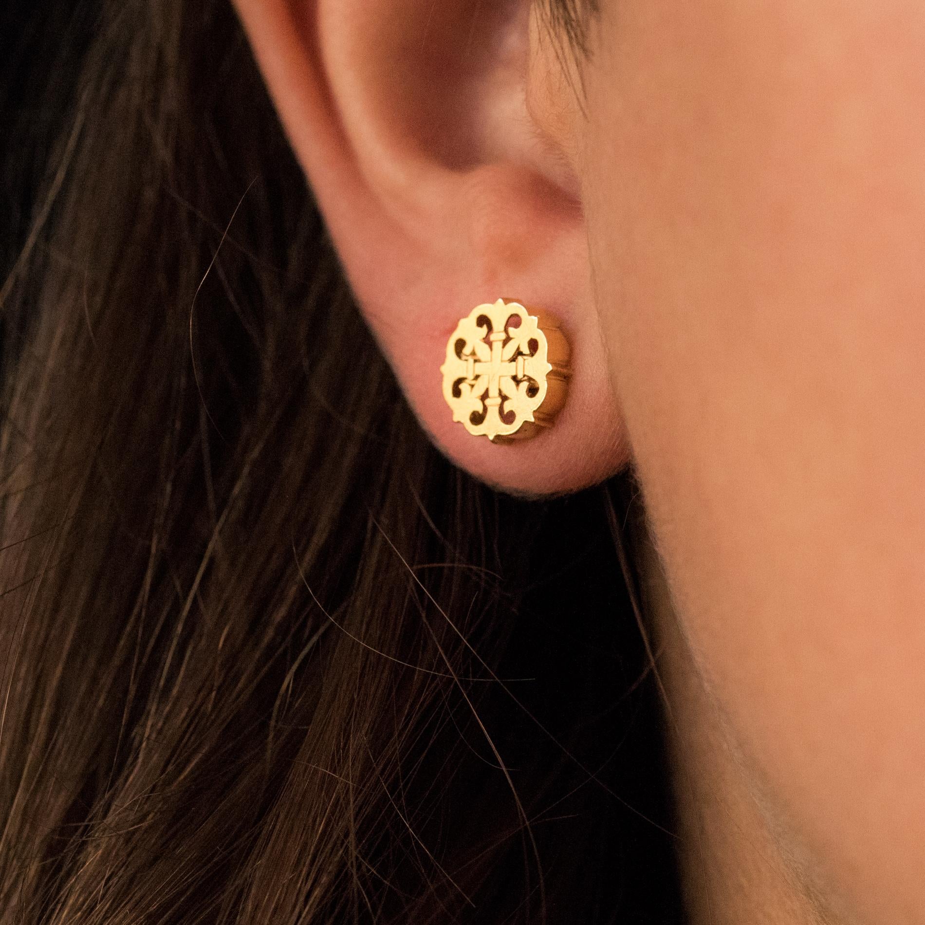 For pierced ears.
Earrings in 18 karats yellow gold.
These antique ear studs are decorated with openwork decoration of a cross and fleur de lys. The entire border is hemmed. The hanging system is an Alpa.
Diameter: 9.7 mm, thickness: 2.2 mm.
Total