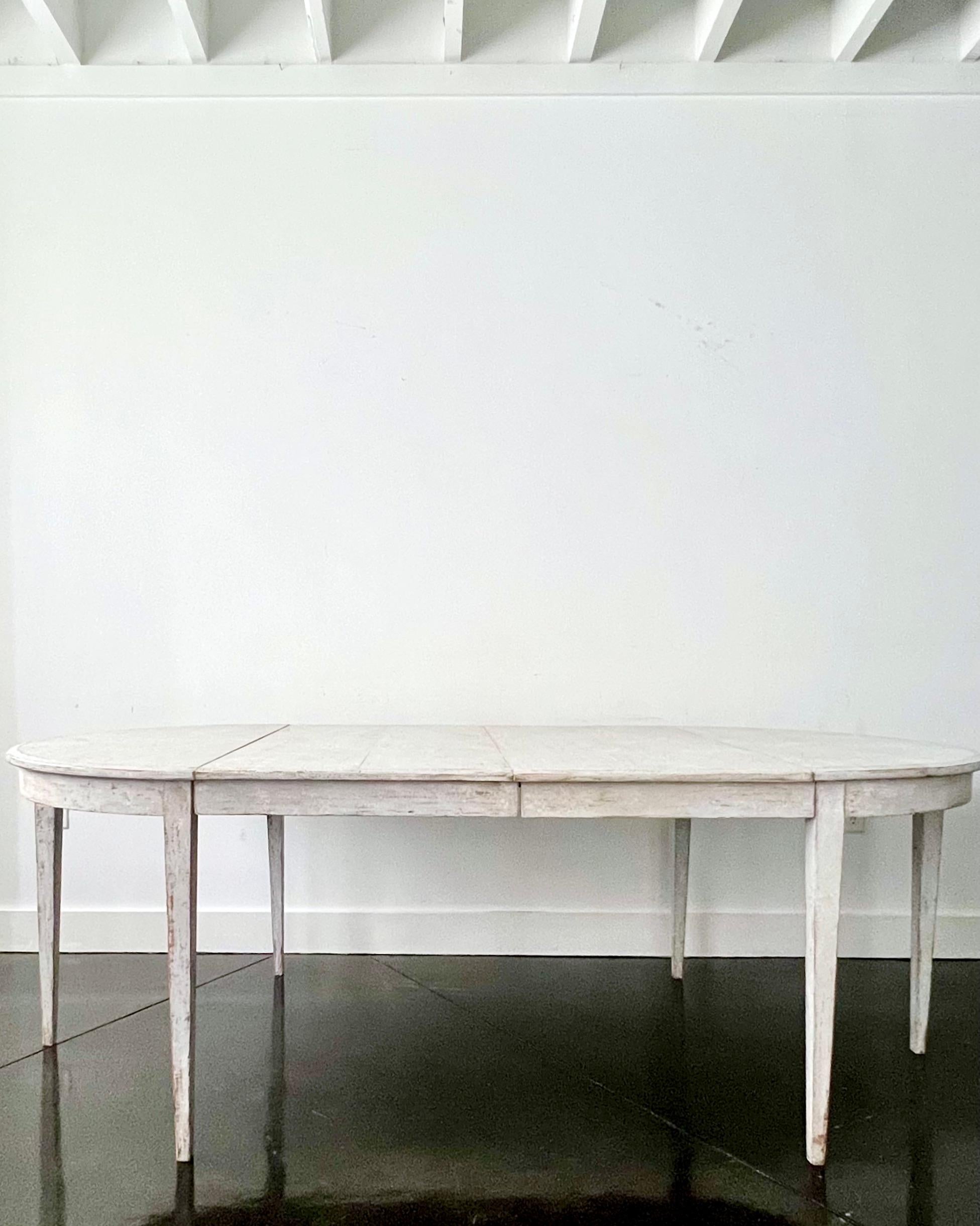 Early 19th century later painted Gustavian period extending table with two leaves and tapered legs. A practical piece that can be used as round table or extended with one or two leaves up to 90