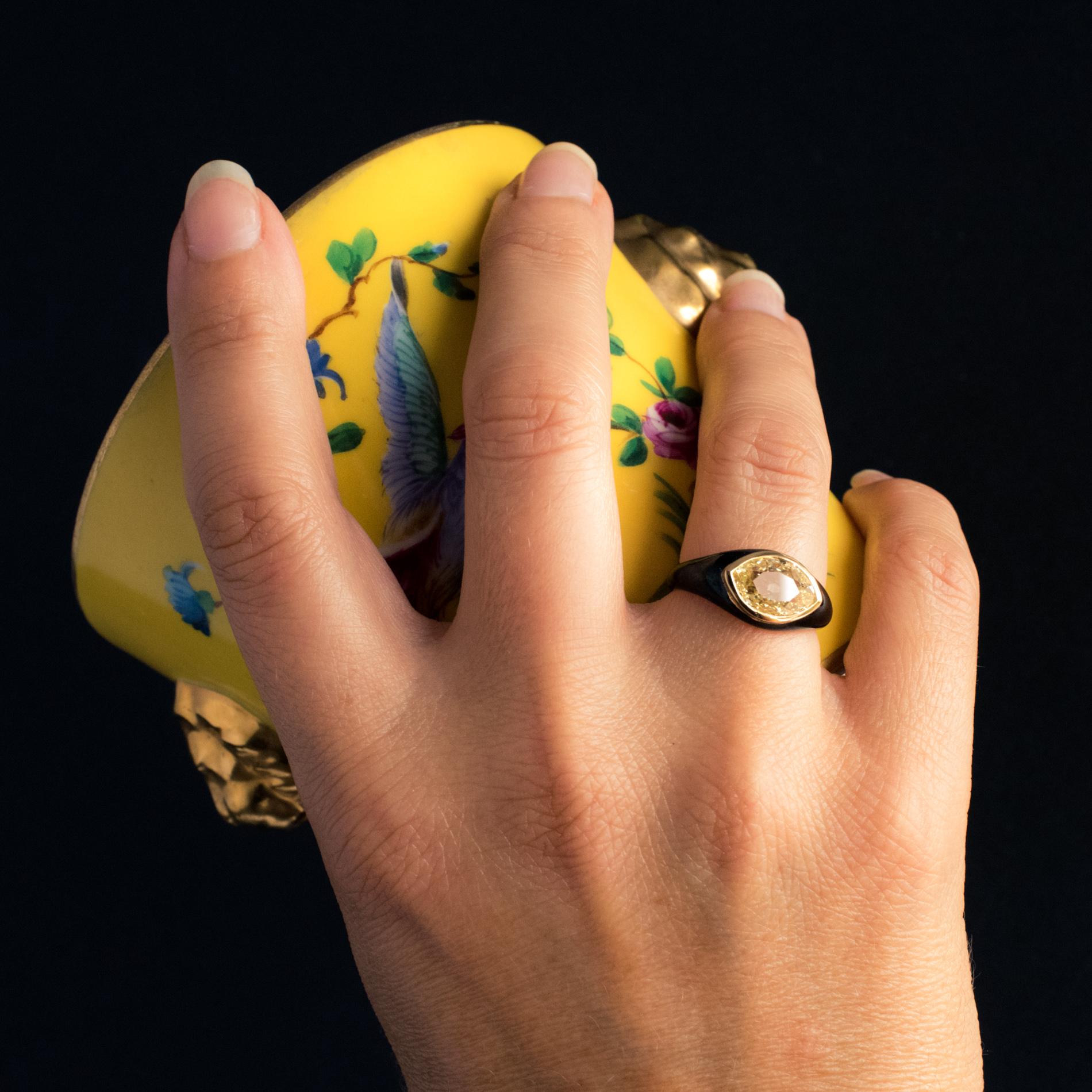Ring in 18 karat yellow gold, eagle's head hallmark.
Incredible antique bangle ring, it is closed set on its top with an antique marquise-cut diamond in fancy yellow. 2/3 of the mounting body is black enamelled.
Total diamond weight : approximately