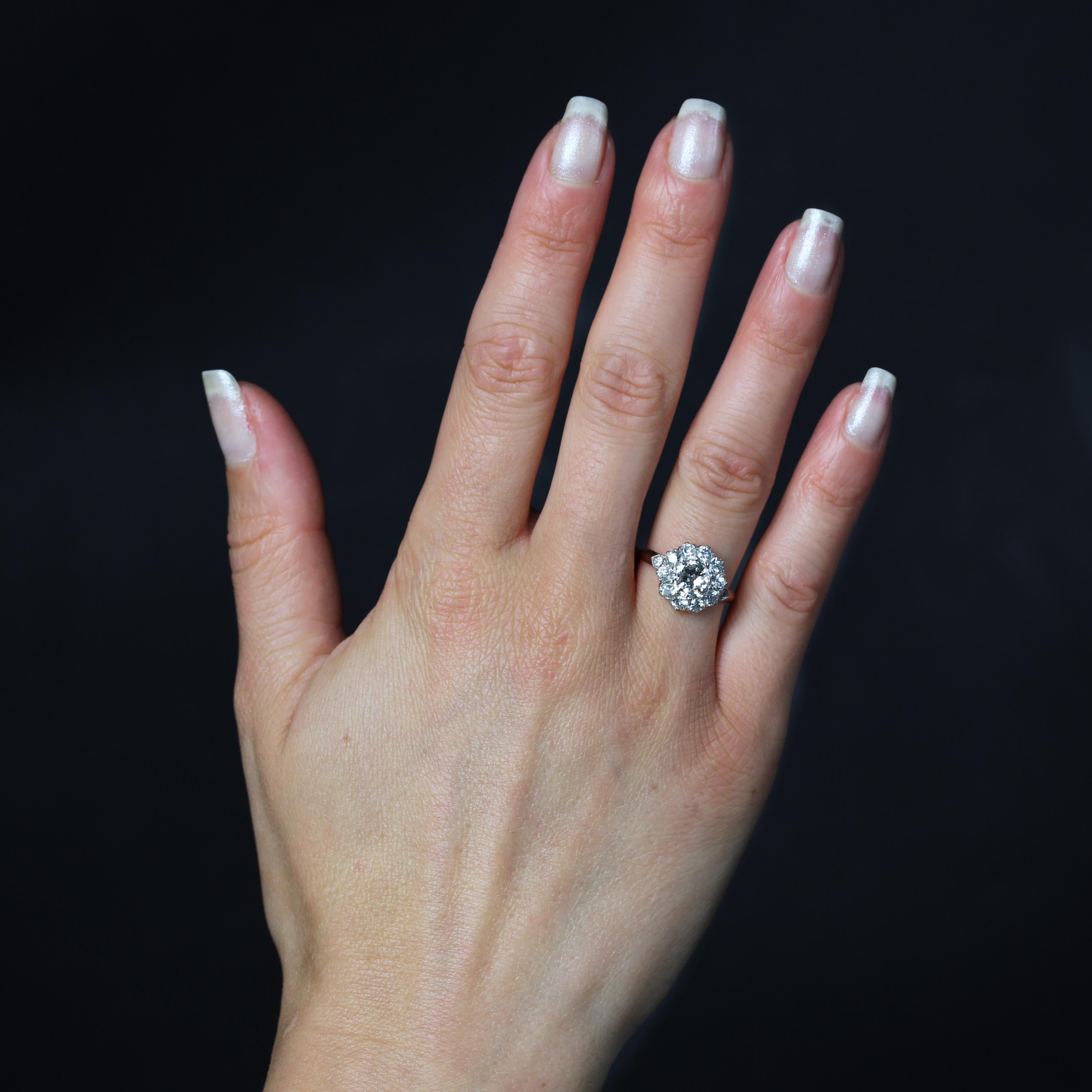 Bague en or jaune 18 carats et en platine.
La monture de cette bague ancienne stylise une fleur de marguerite dont le cœur et les pétales sont représentés par des diamants de taille brillant à l'ancienne, celui du centre étant plus important, tous