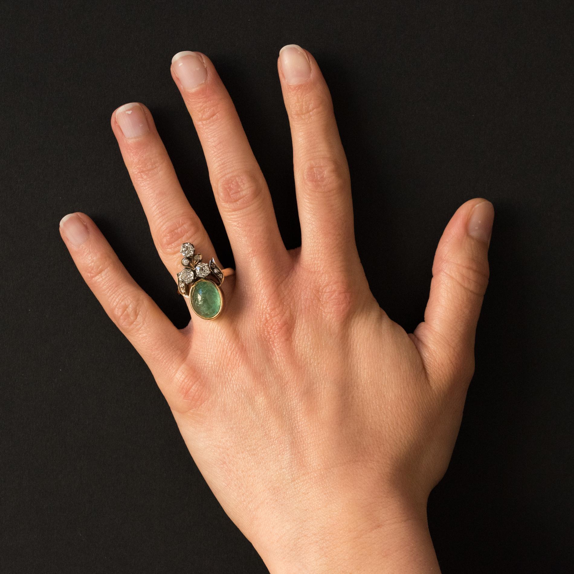 Ring in 18 karats yellow gold, weevil hallmark and silver.
Important antique ring called Duchess ring, it is set with a cabochon emerald in closed setting surmounted by 2 antique cushion- cut diamonds set with claws, and a fleur-de-lis motif set