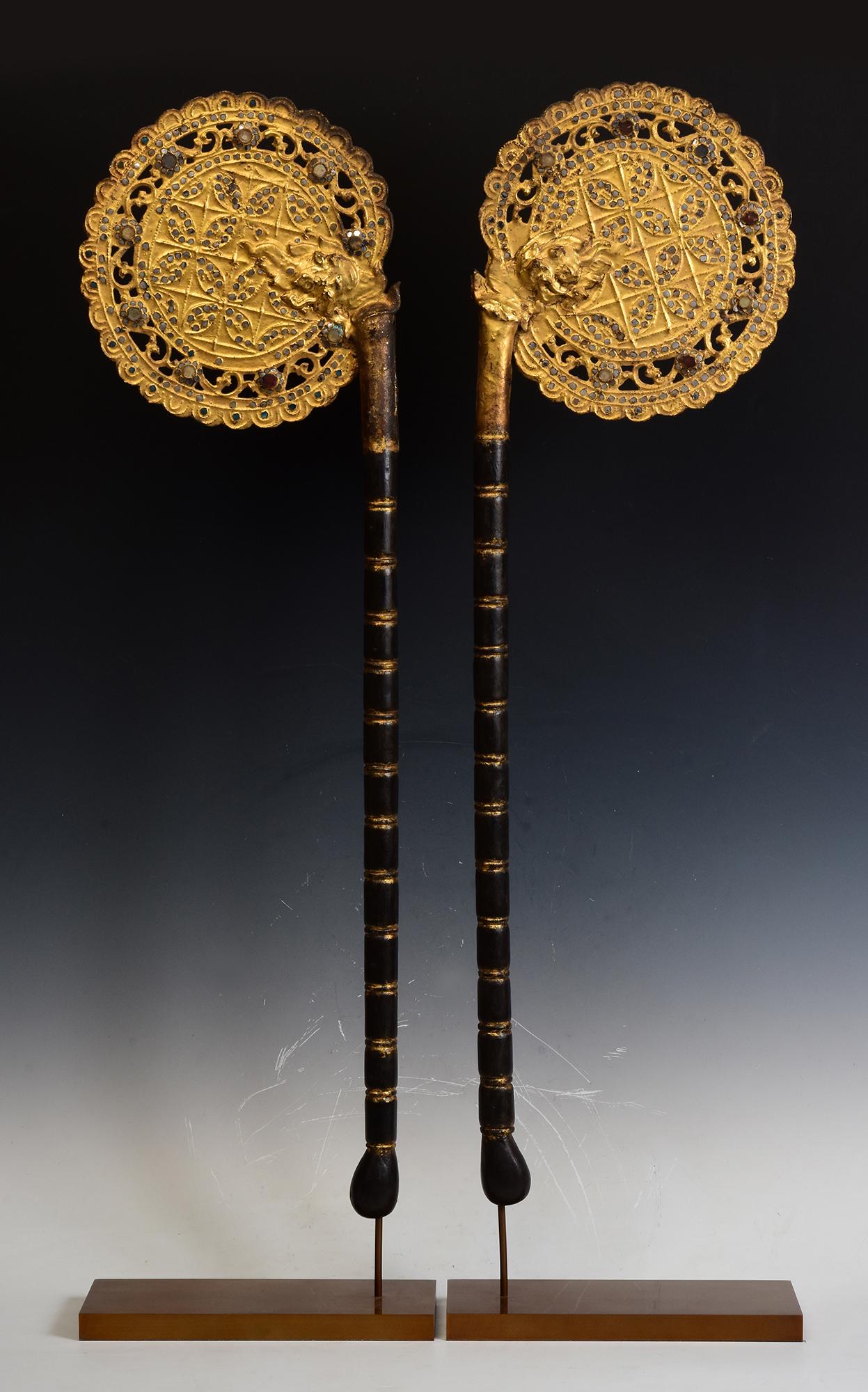 A pair of antique Burmese wooden fans with gilded gold and glass.

Age: Burma, Mandalay Period, 19th Century
Size of fans only: Height 88.5 - 89.5 C.M. / Width 25.3 C.M.
Height including stand: 98 - 98.5 C.M.
Condition: Nice condition overall (some