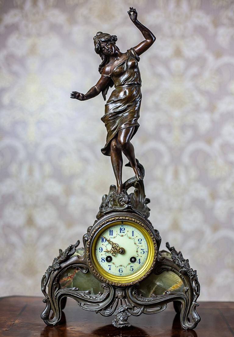 We present you this French figurative mantel clock made of bronzed metal and green onyx.
It was manufactured in the second half of the 19th century.
The mechanism is signed by AD.Mougin Deux Medailles Paris.
(The mark had been in use until the