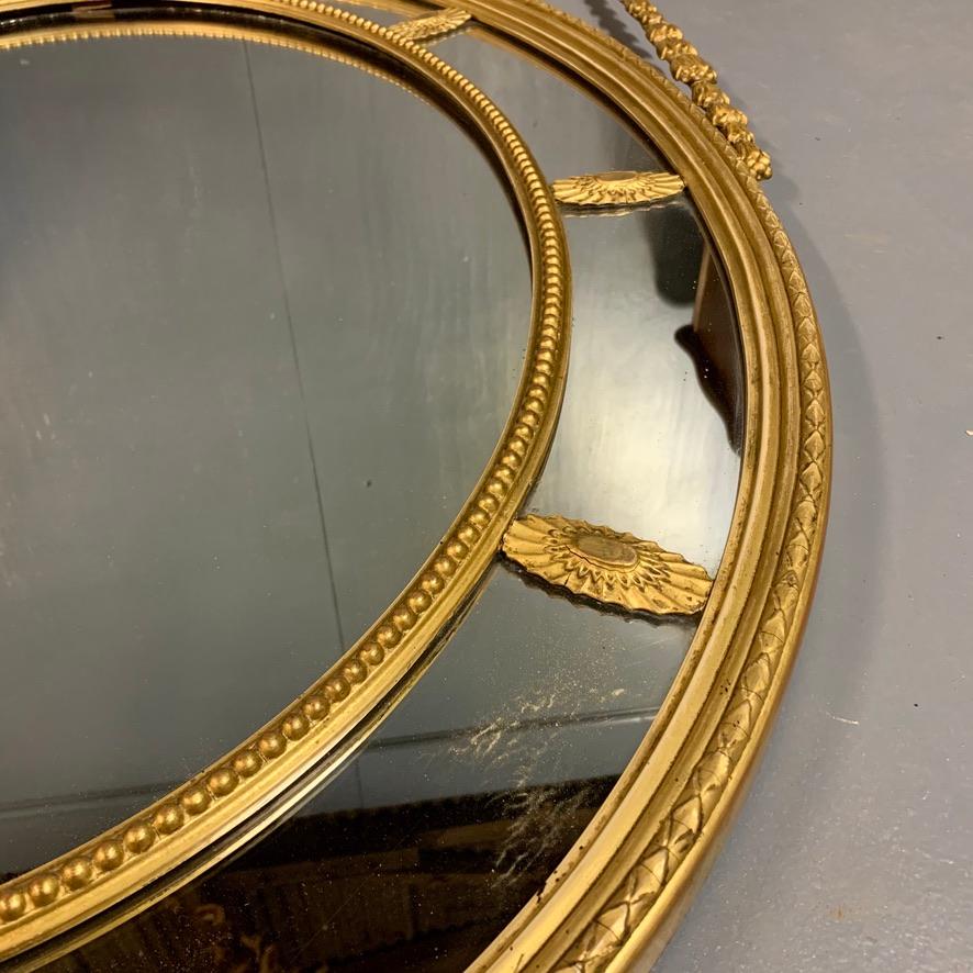 Late 19th Century 19th Century Adams Style Oval Gilt Mirror with Tied Ribbons and Urn Decor