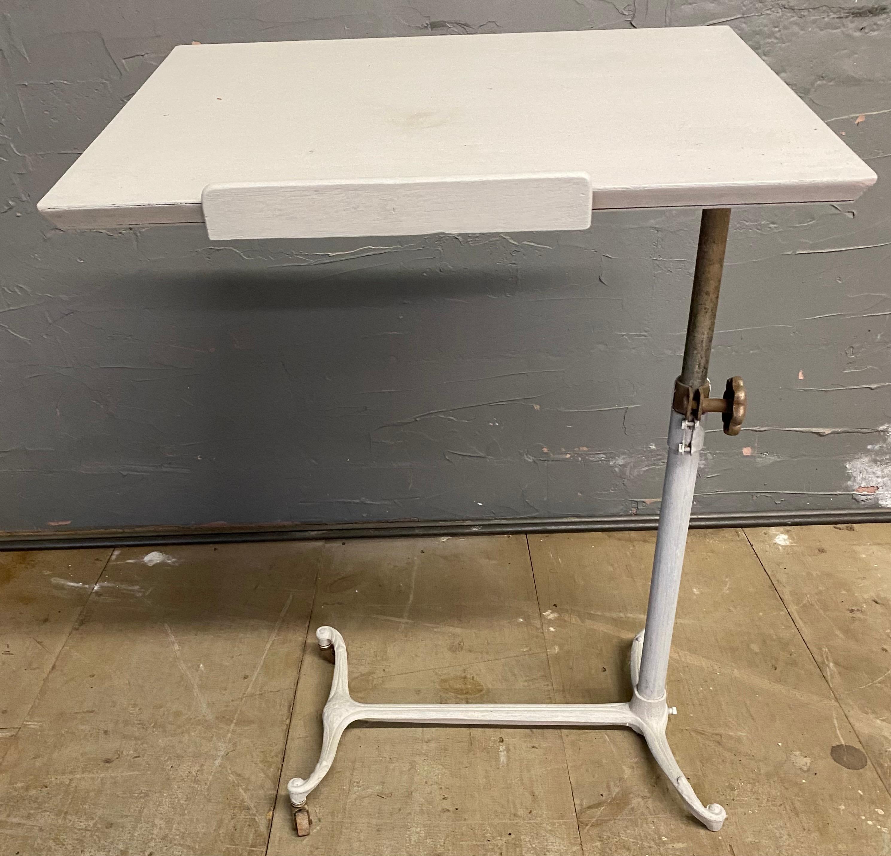 Antique adjustable tilt-top table with cast iron base with painted wood work or table surface that lends itself to be used as an end table, side table, bedside table or nightstand. Height (when top is flat) can be raised or lowered from 24.5 - 40
