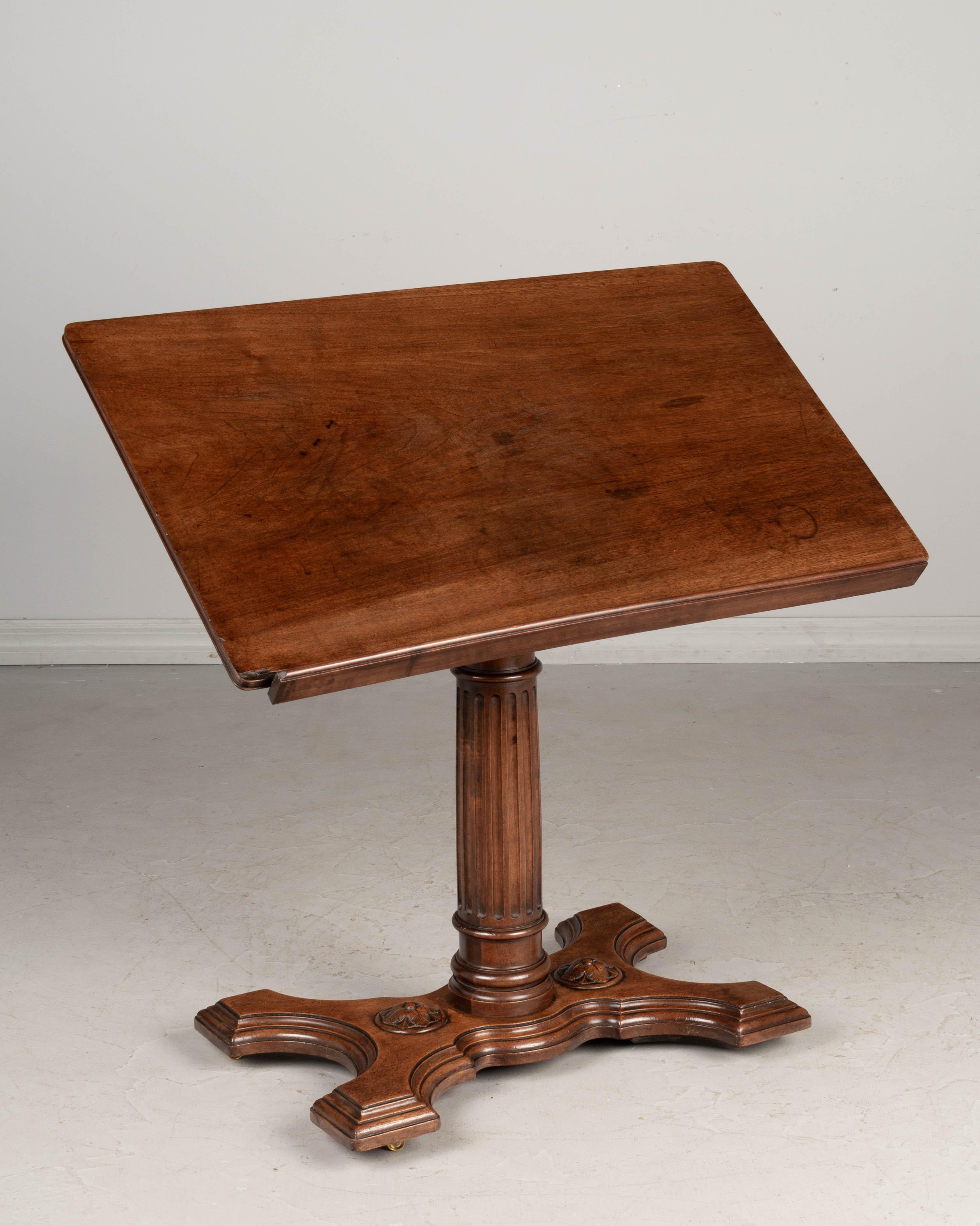 A 19th century French adjustable tilt-top table, or easel, made of solid walnut with a sturdy turned post and cast brass mechanism. Beautiful character and patina with waxed finish. Tabletop may be tilted flat or angled and has a small latched ledge