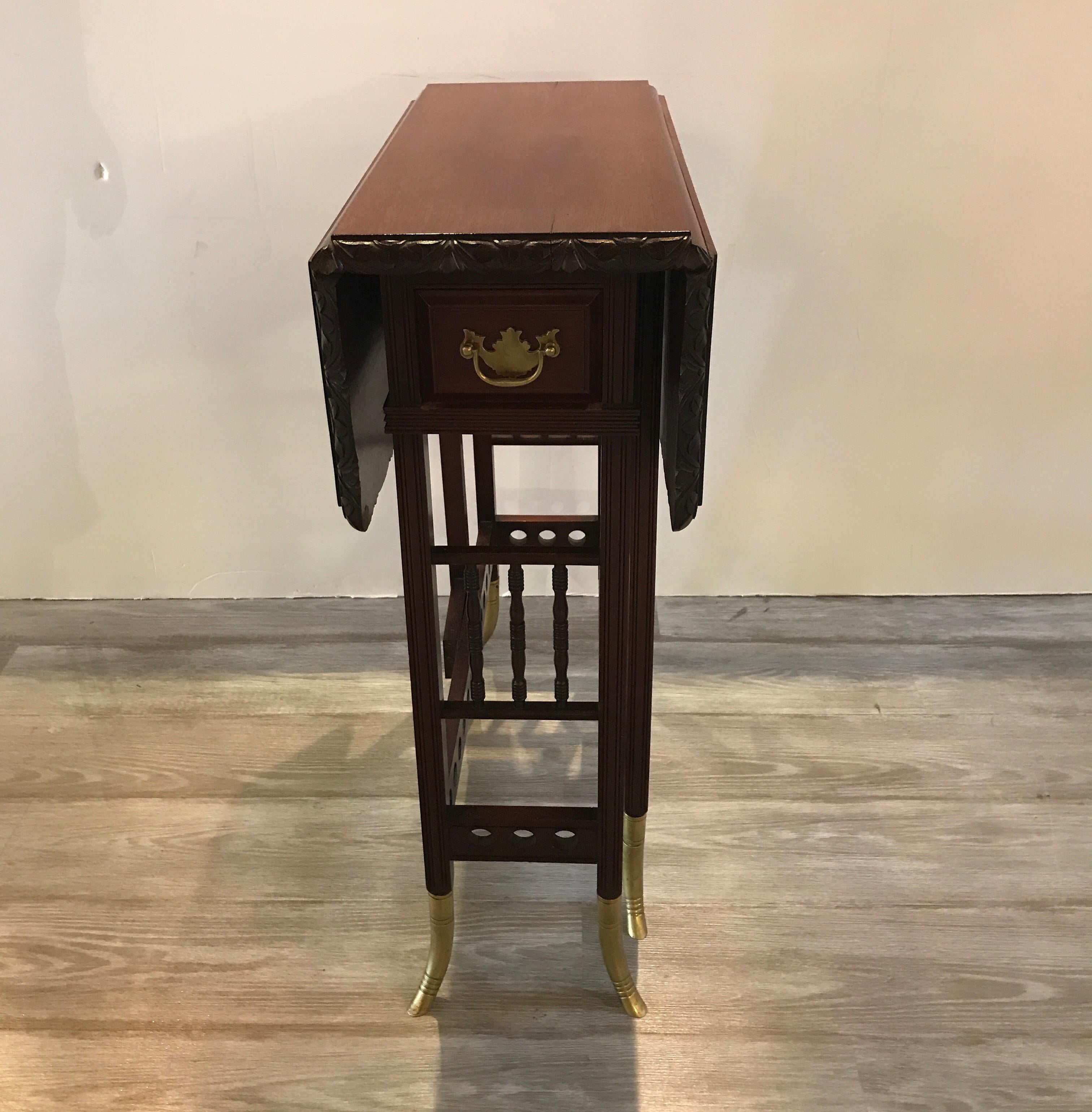 Exceptional drop leaf card table with original bronze mounts and small center drawer. The narrow table with carved edge with generous drop leaf on each side. The brass feet are a classic style of A & H Lejambre during the aesthetic movement of the