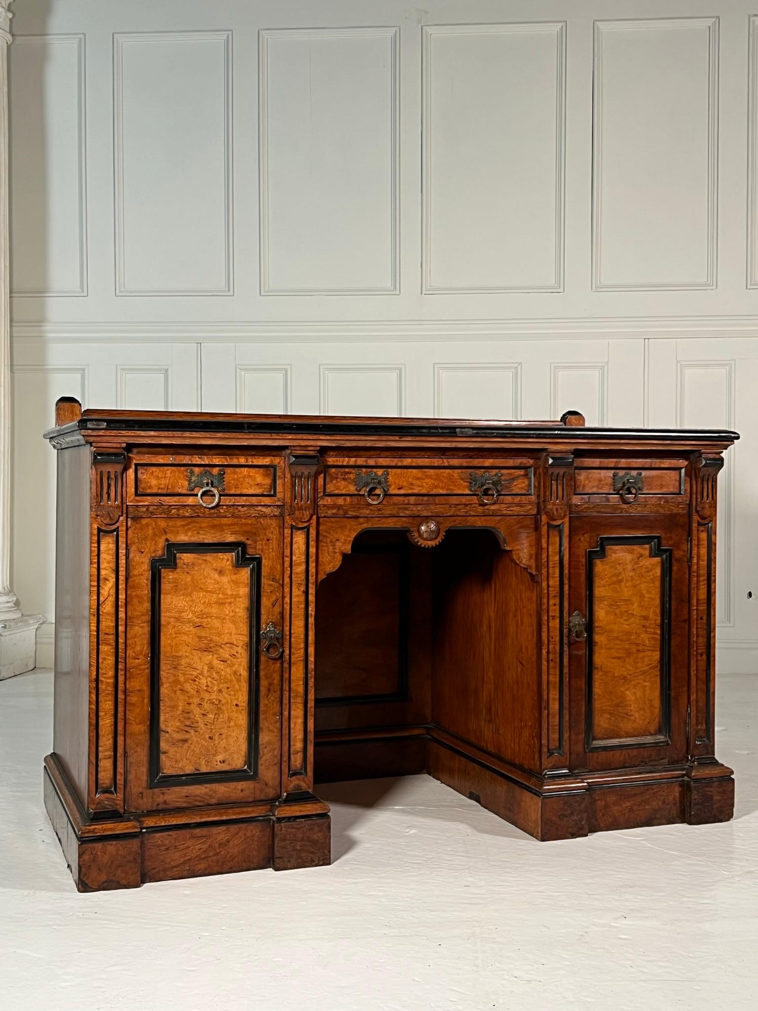 Exceptional quality desk produced during the Aesthetic movement.

Oak plank top with upstand, three drawers over two cupboards with burr veneer and satinwood inlay and ebonised detailing.

Age related wear and a repair to one handle as