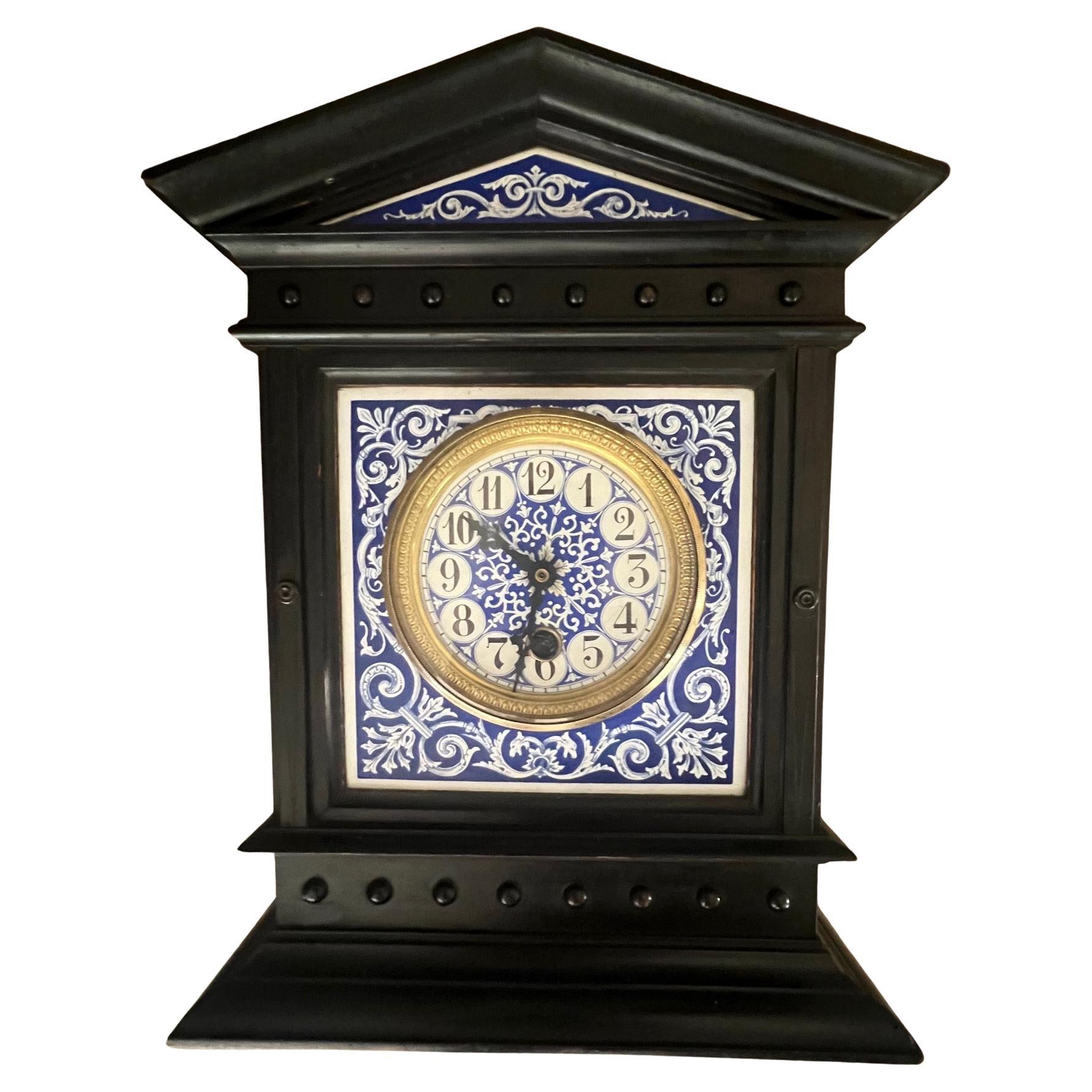 Aesthetic movement mantle clock made in France in the late 19th century. The face is blue and white hand painted enamel centered over blue and white porcelain. The round case which is made of brass opens for cleaning.  The inside has been converted