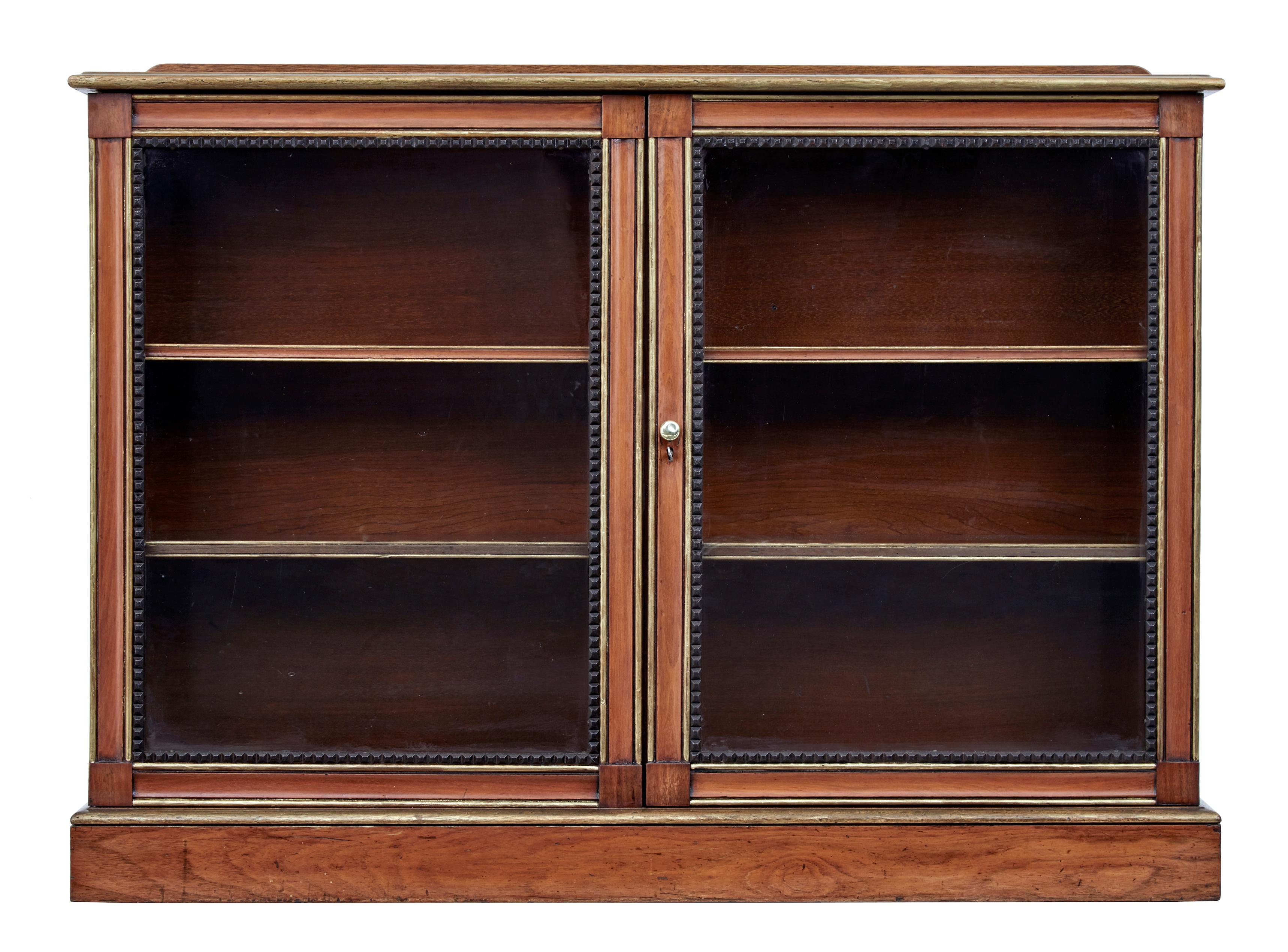 19th century aesthetic movement walnut and mahogany bookcase, circa 1880.

Good quality walnut glazed door bookcase. Walnut top surface with short gallery, gilt edging to top/bottom and doors. Doors further decorated with ebonised dentil