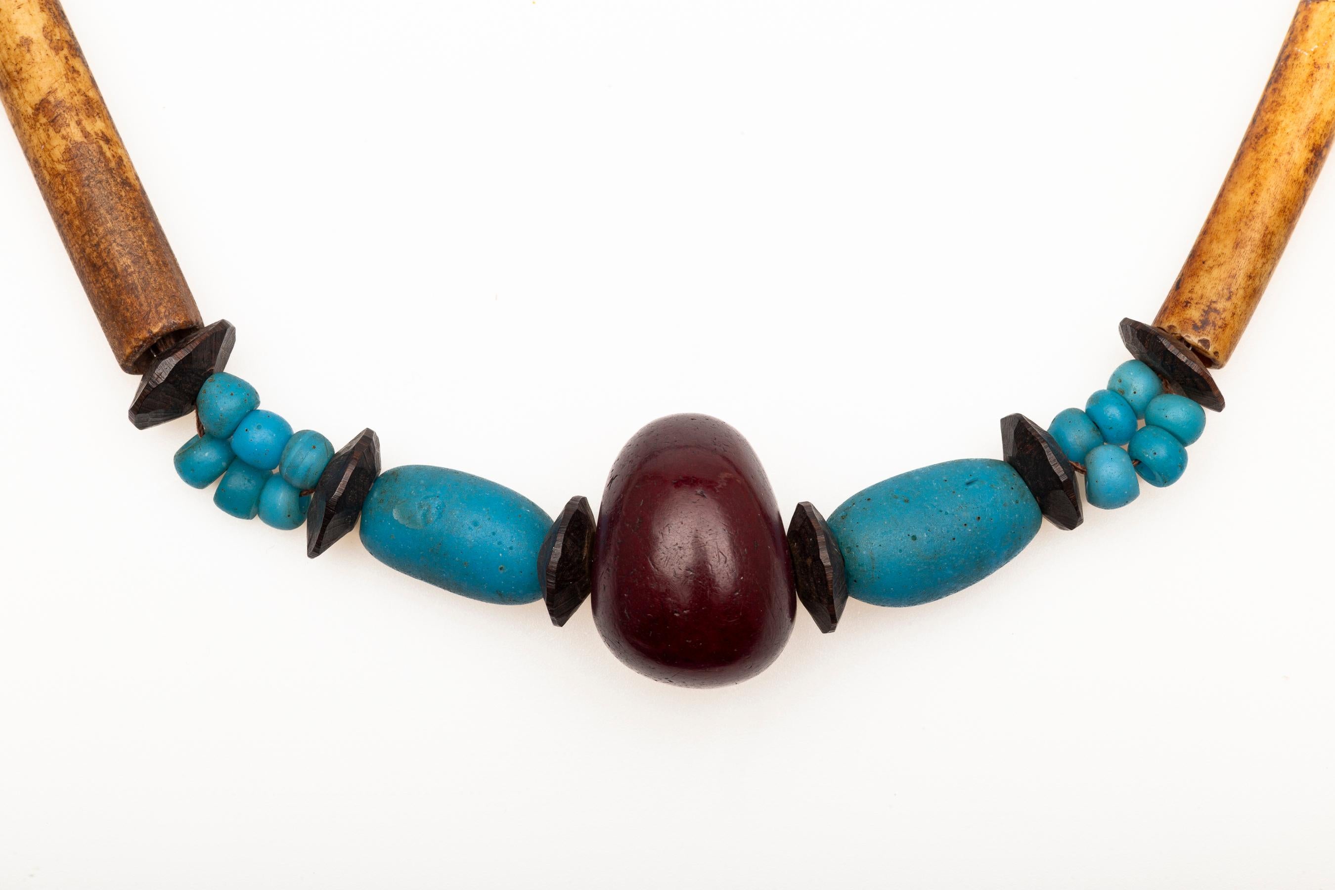 This is an Antique African necklace which in and of itself is unique. Is is one of a kind made by an African jewelry maker. It holds bone, glass turquoise beads and a central amber. Striking and in excellent condition the length is 28 inches. Weight