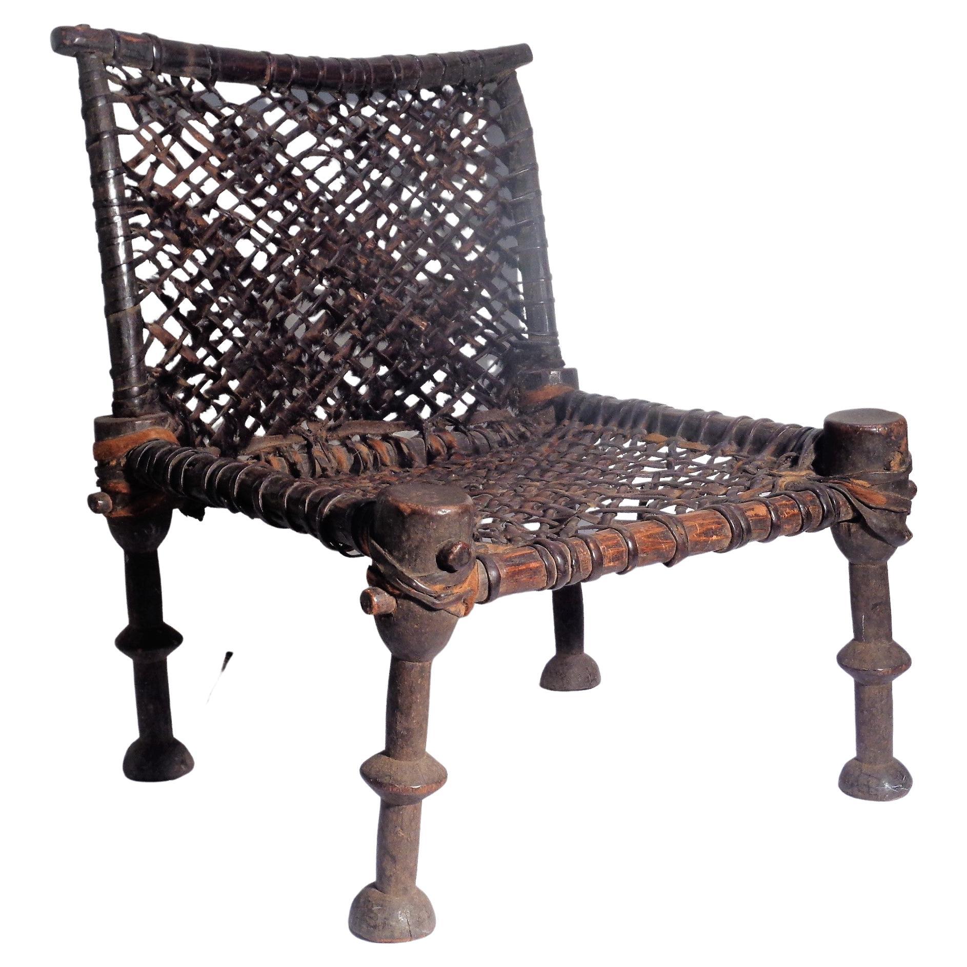 19th century African hand carved wood chair w/ leather goatskin hide woven webbing in original as found antique condition with no restorations. Overall beautifully aged color patina. Look at all pictures and read condition report in comment section.