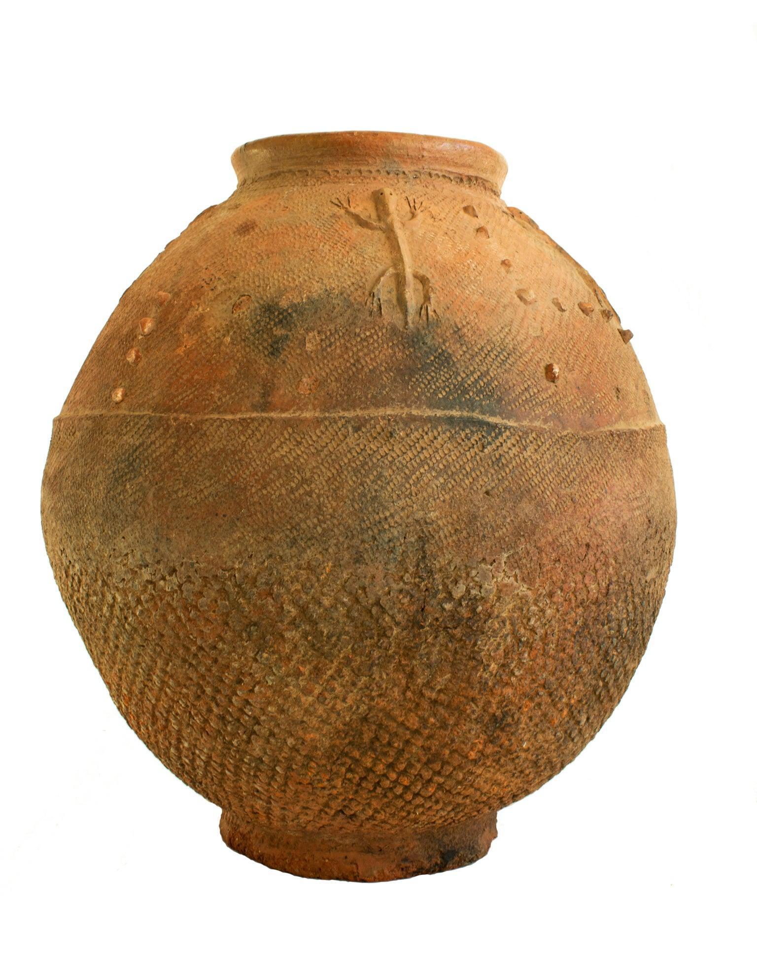 19th century African red clay water vessel from Bambara Jidaga with lizards. A unique Wessel formed by pounding flattened clay around a convex mold, this oblong footed vessel is a water storage jar known as a Jidaga, created by women of the Bambara