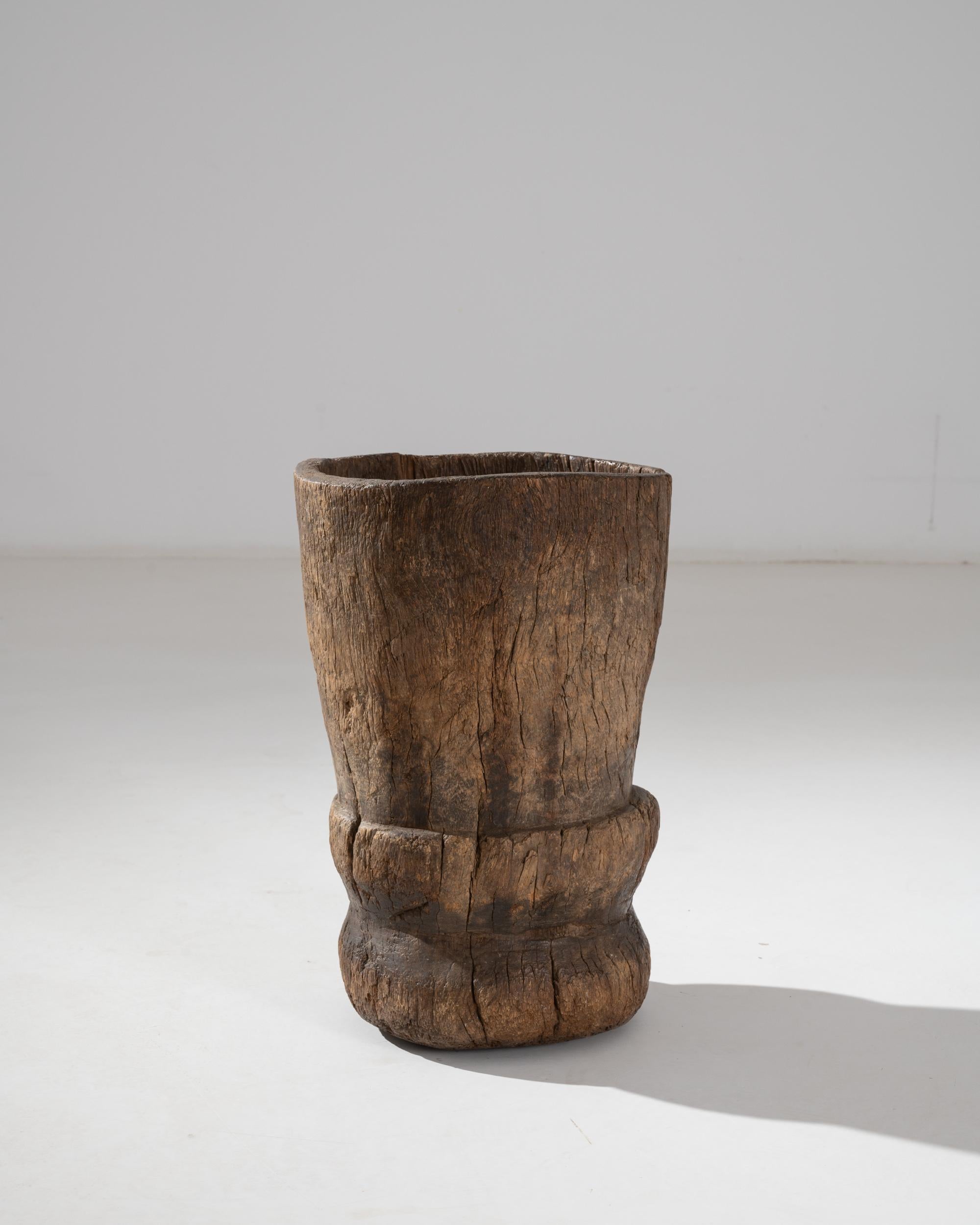 The muscular simplicity and tactile appeal of this antique wooden mortar give it a majestic sculptural quality. Made in Africa in the 1800s, the large size of this piece indicates that it would have been originally used to hull grain. The high-sided