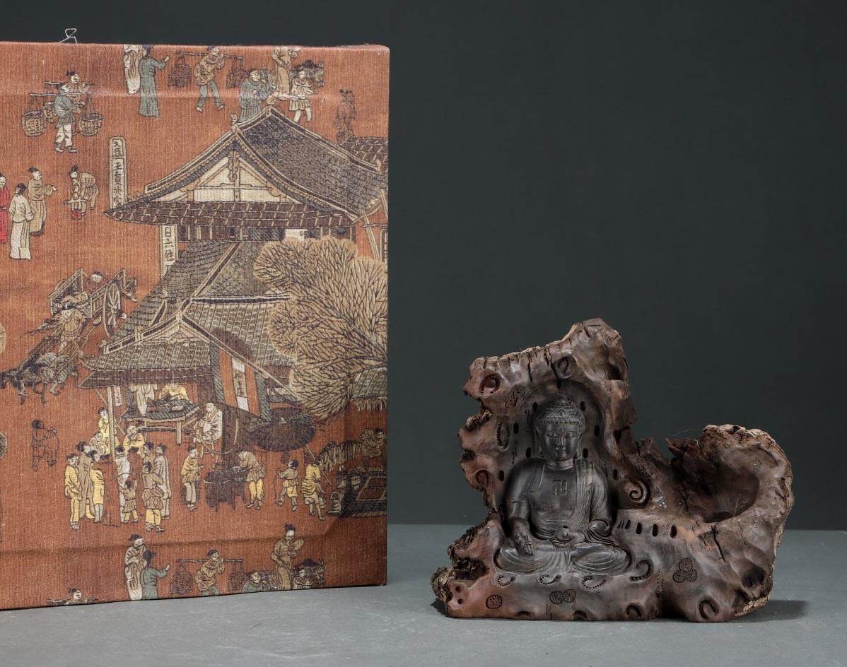 This 19th Century Agarwood Engraving of Vairocana Buddha, seated in a serene cave setting, is a remarkable work of spiritual artistry and craftsmanship. Carved from high-quality agarwood, a material revered for its calming aroma and spiritual