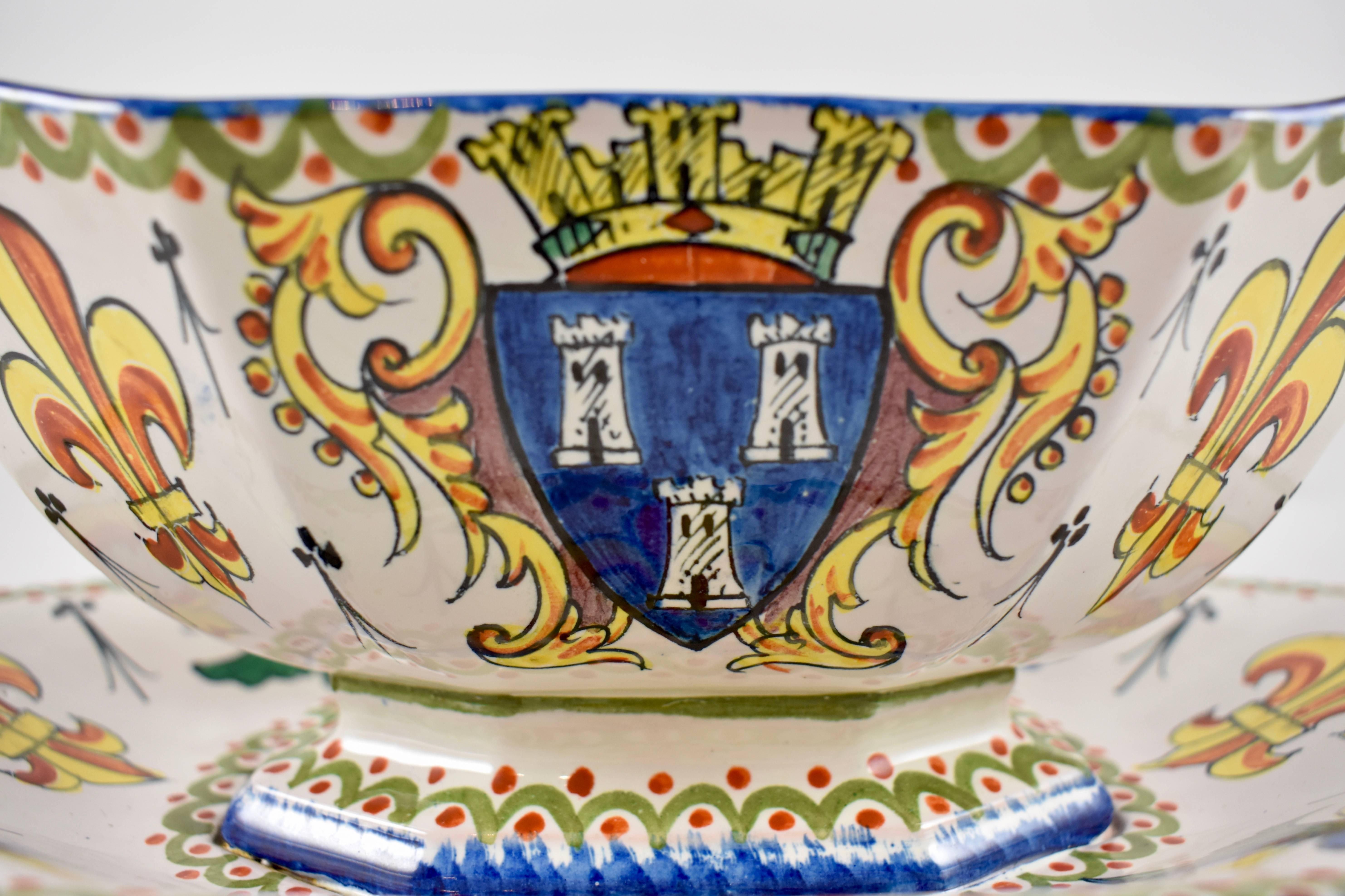 A French faïence armorial sauce boat, Alcide Chaumeil, circa 1880-1890. 
Hand decorated with a French heraldic crest, fleur-de-lis, and the customary border, the boat is fixed to a bottom tray. Glazed in vibrant colors.

 An initialed mark and the