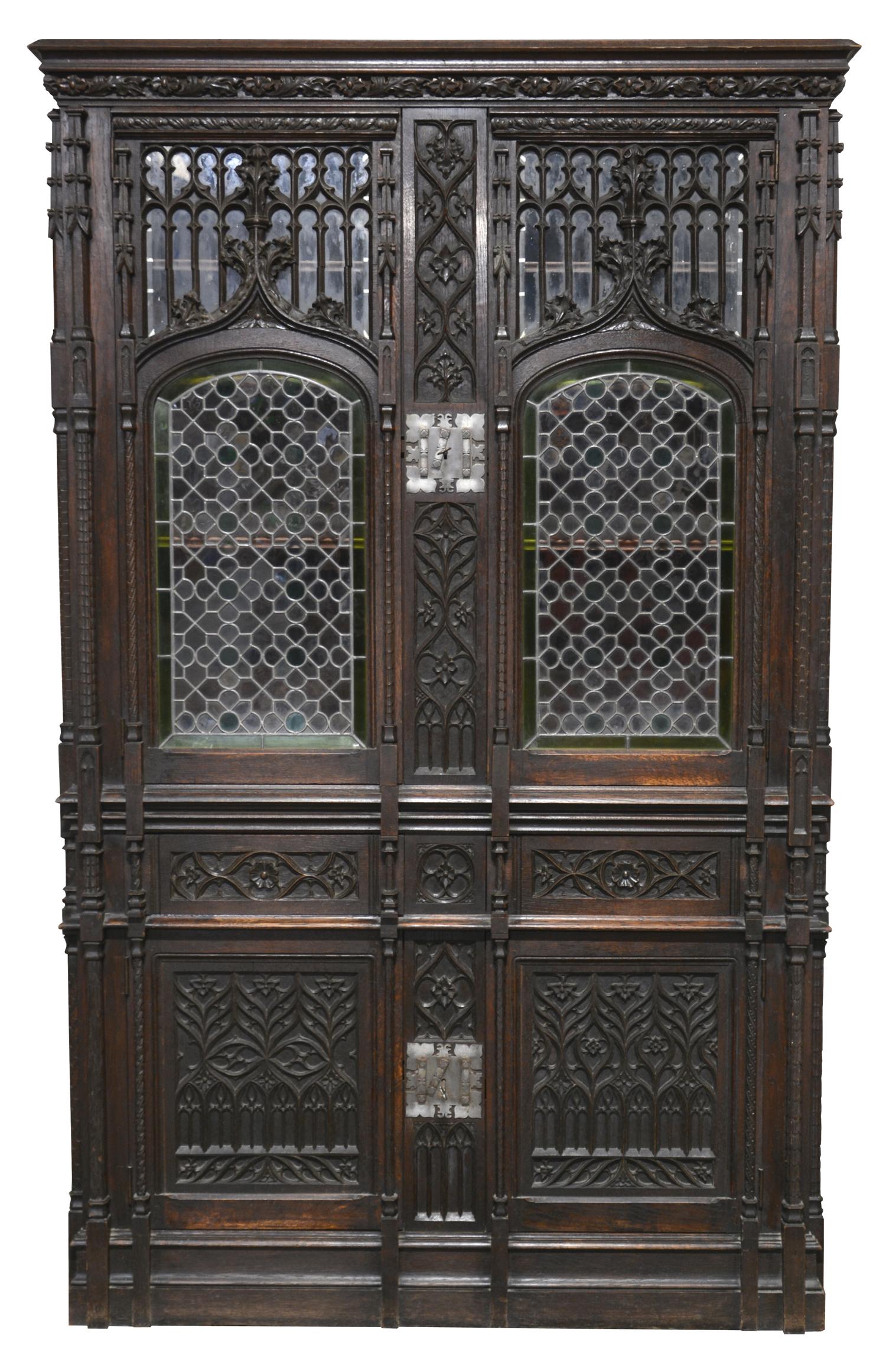 An amazing 19th century amazing Gothic Revival bookcase in the spirit of Violet-Le-Duc.

Like a Gothic Cathedral! This gorgeous oak bookcase is finely carved with Gothic patterns. Two leaded and stained doors, 2 drawers and 2 carved doors at the
