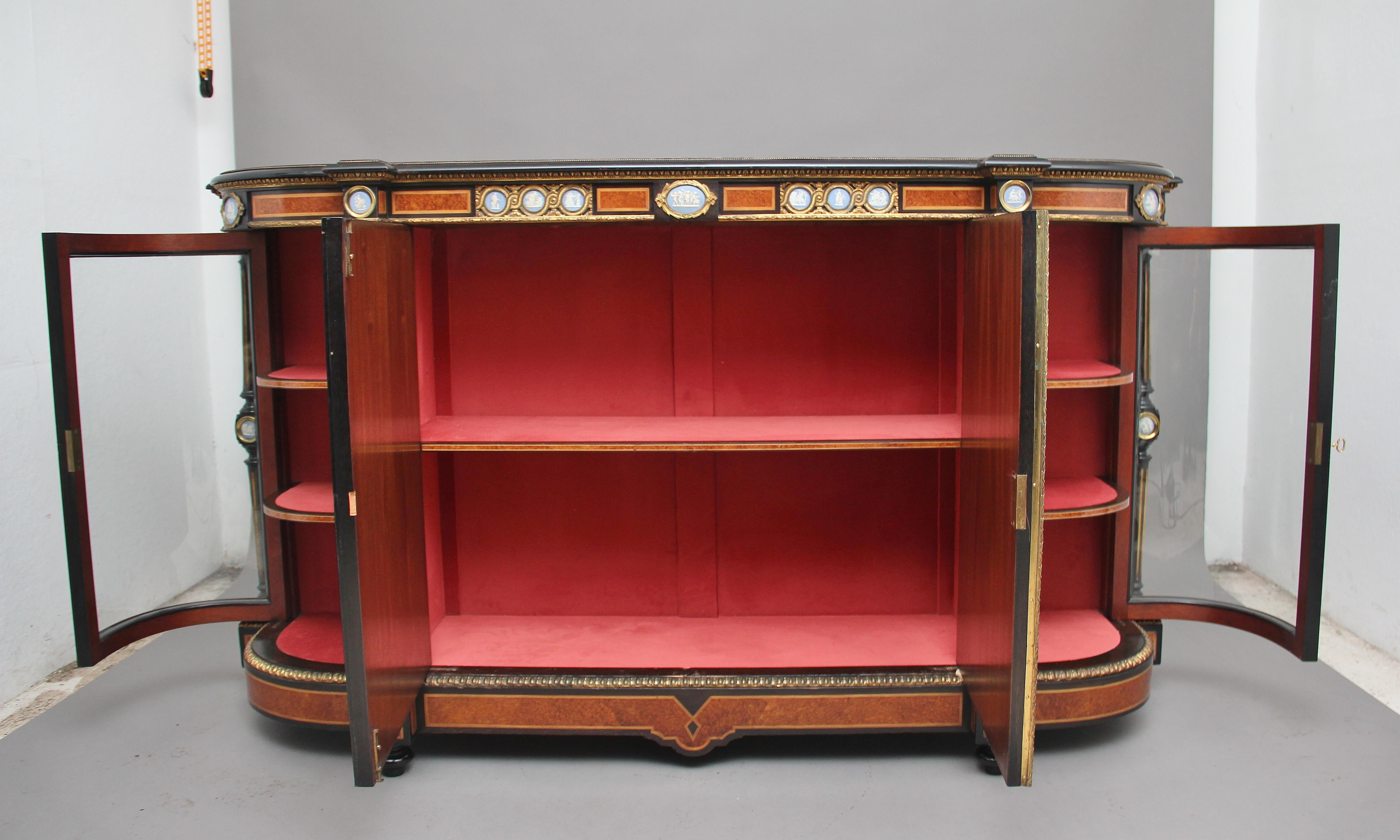 Credenza/armadio di qualità espositiva del XIX secolo in amboyna ed ebanizzato con colonne tornite e scanalate, porte in vetro ad arco e porte centrali con pannelli in pietra dura e deliziosi pannelli in legno di cuneese con cornici in ottone
