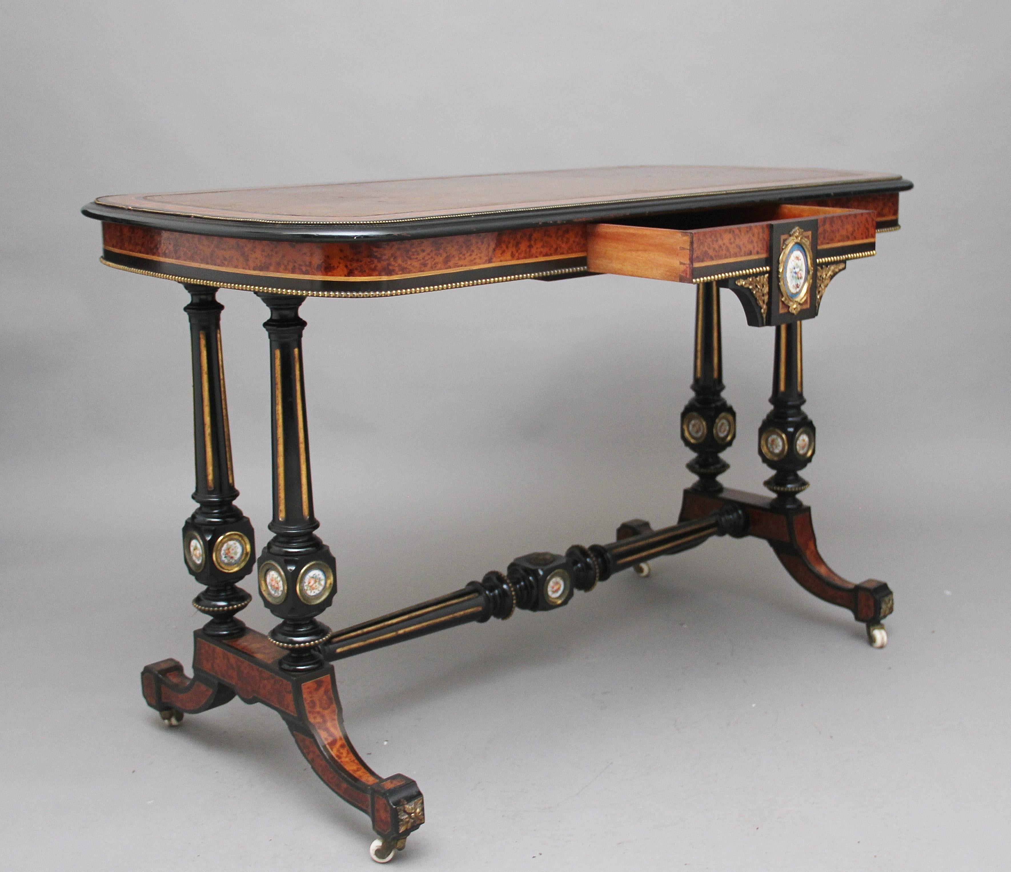 19th century amboyna and ebonised centre / sofa table, the rounded rectangular top with ormolu beading, ebonised edge and amboyna banding, with black leather top decorated with blind and gold tooling, the frieze below decorated with ormolu beading