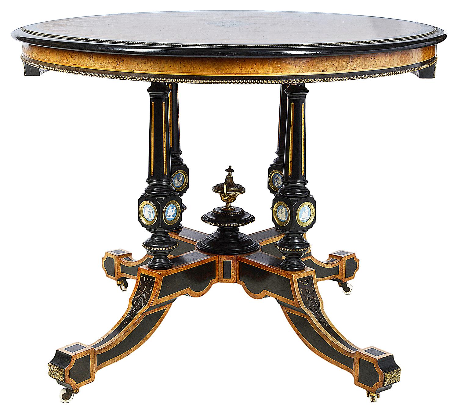 A very good quality 19th century Amboyna center table, with Wedgwood porcelain plaques depicting classical scenes, having parcel gilt decoration and ormolu mounts and raised on a four splay base.
In the manner of Holland and Son.

The firm of