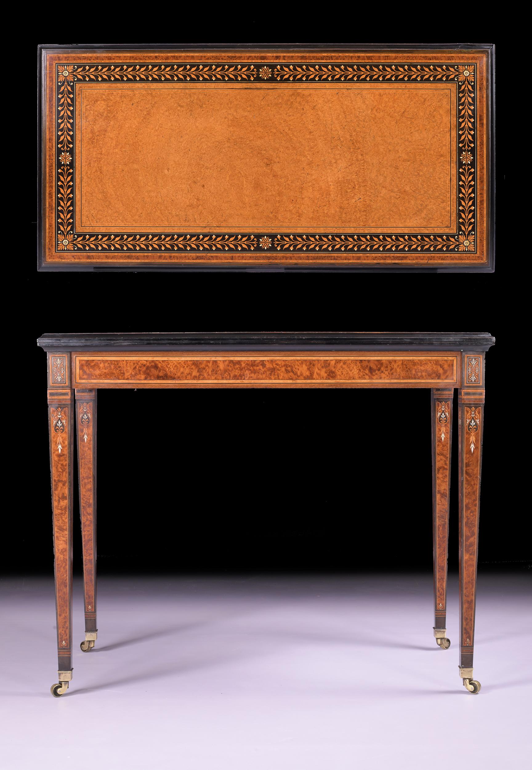 Exceptionnelle table à jeux en amboine et ébène du XIXe siècle, attribuée à Holland & Sons. Le plateau rectangulaire à charnière, décoré d'un bandeau de feuilles, s'ouvre sur une surface de jeu en baize bordeaux, au-dessus d'une frise unie reposant