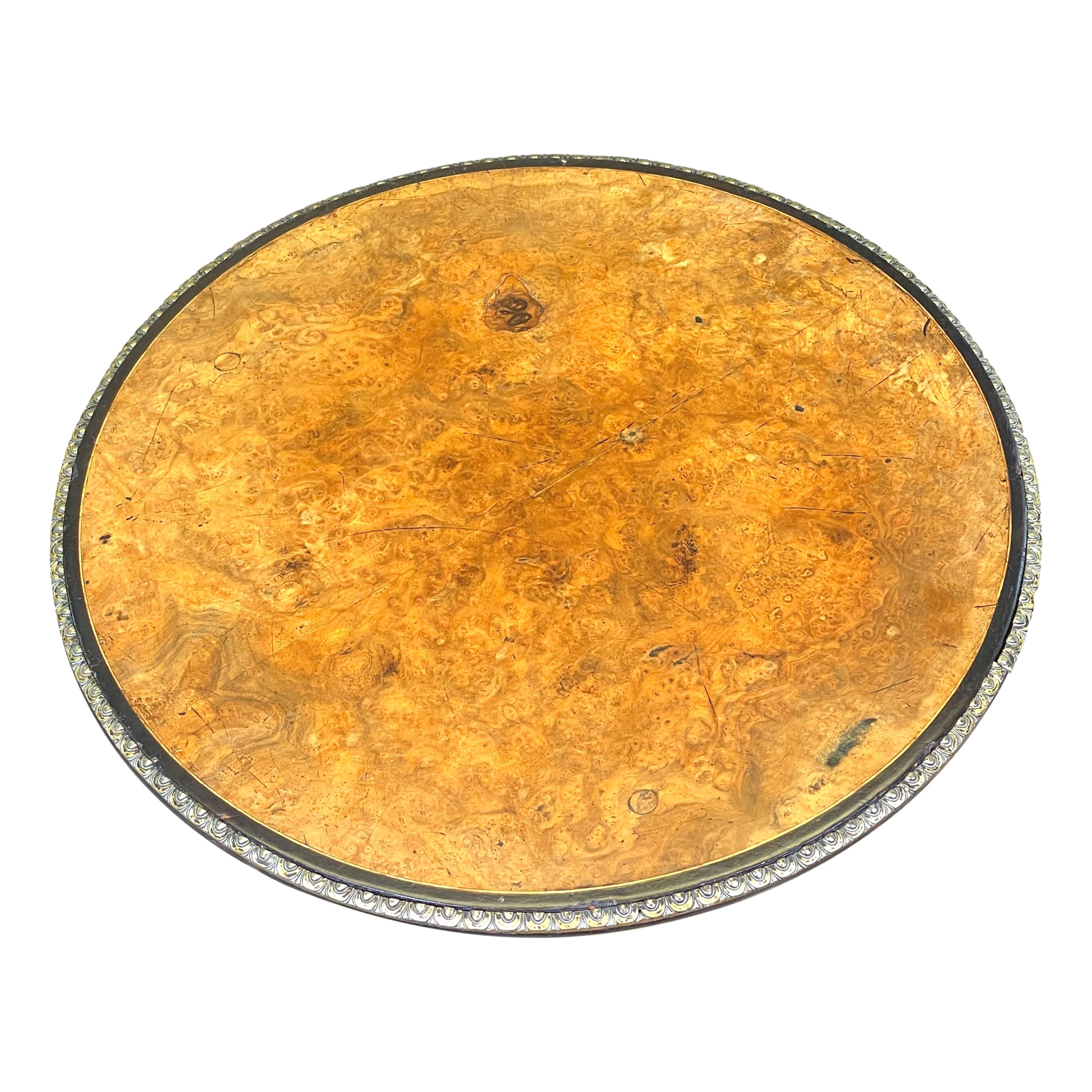 Deliziosa lampada occasionale o tavolo da vino del XIX secolo, con piano circolare in amboyna ben figurato e modanature in ormolu, sollevato su tre eleganti supporti torniti ebanizzati e intarsiati, terminanti con un plateau triforme ed eleganti