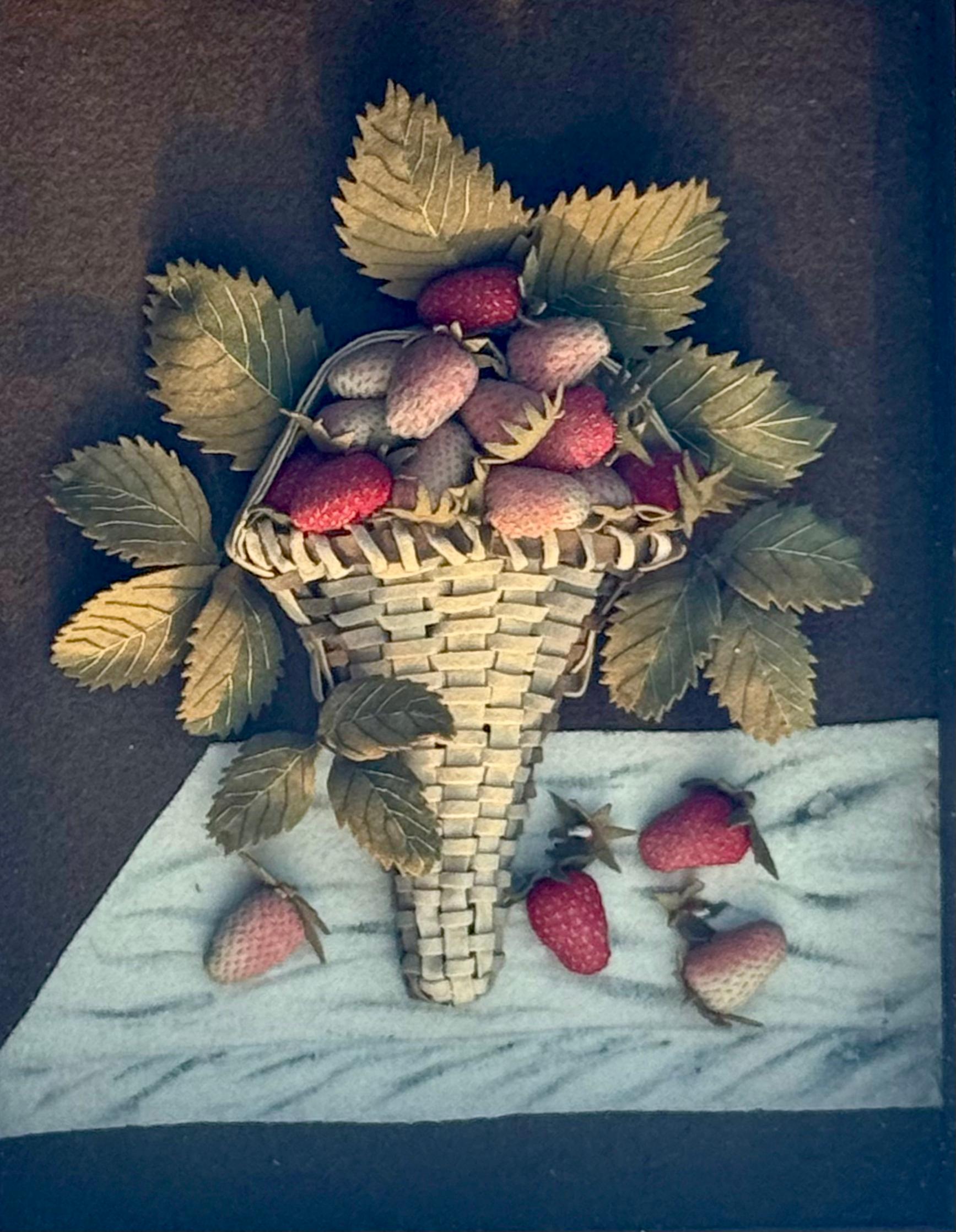 Excelente aplique de fieltro del siglo XIX que representa una cesta de fresas sobre tablero de mármol.  La foto está contenida en un marco de caja de sombra que mide 16,5