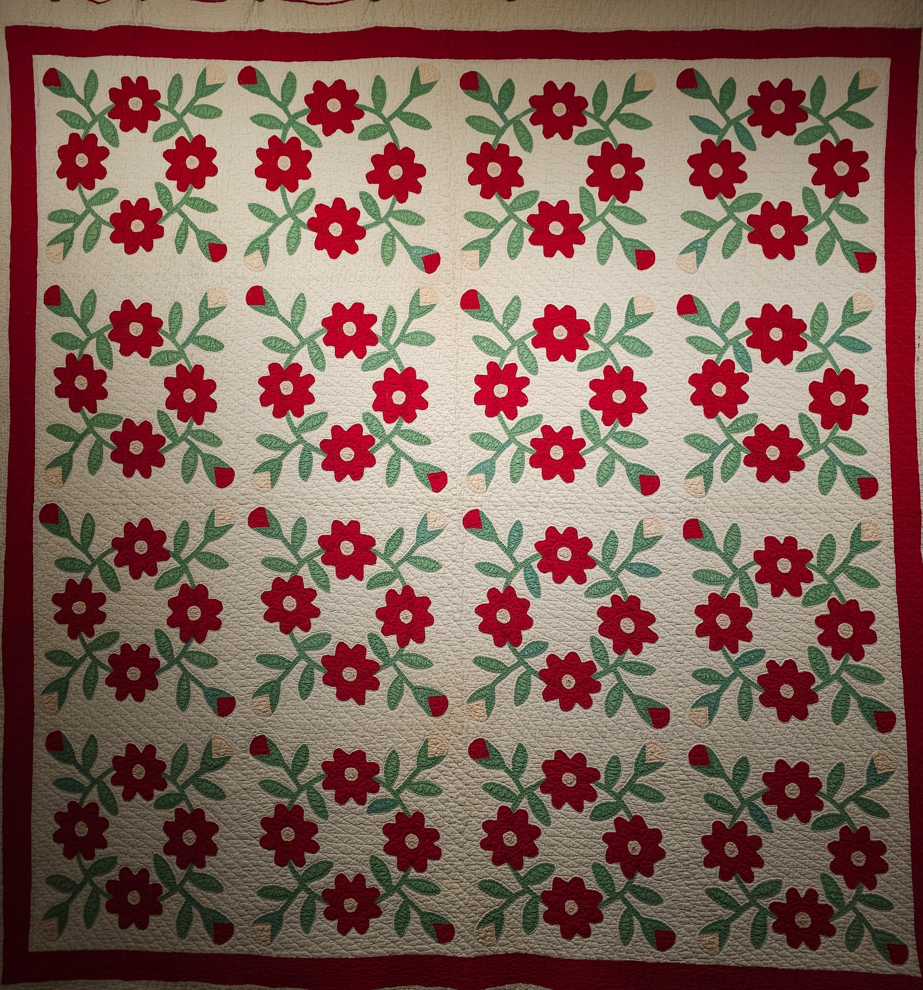 This beautiful American Applique Quilt was hand stitched in the late 1800s in Pennsylvania in the United States. The American Applique Quilt is in “Floral” pattern with red and pink flowers with green stems and leaves on a white field. The quilt was