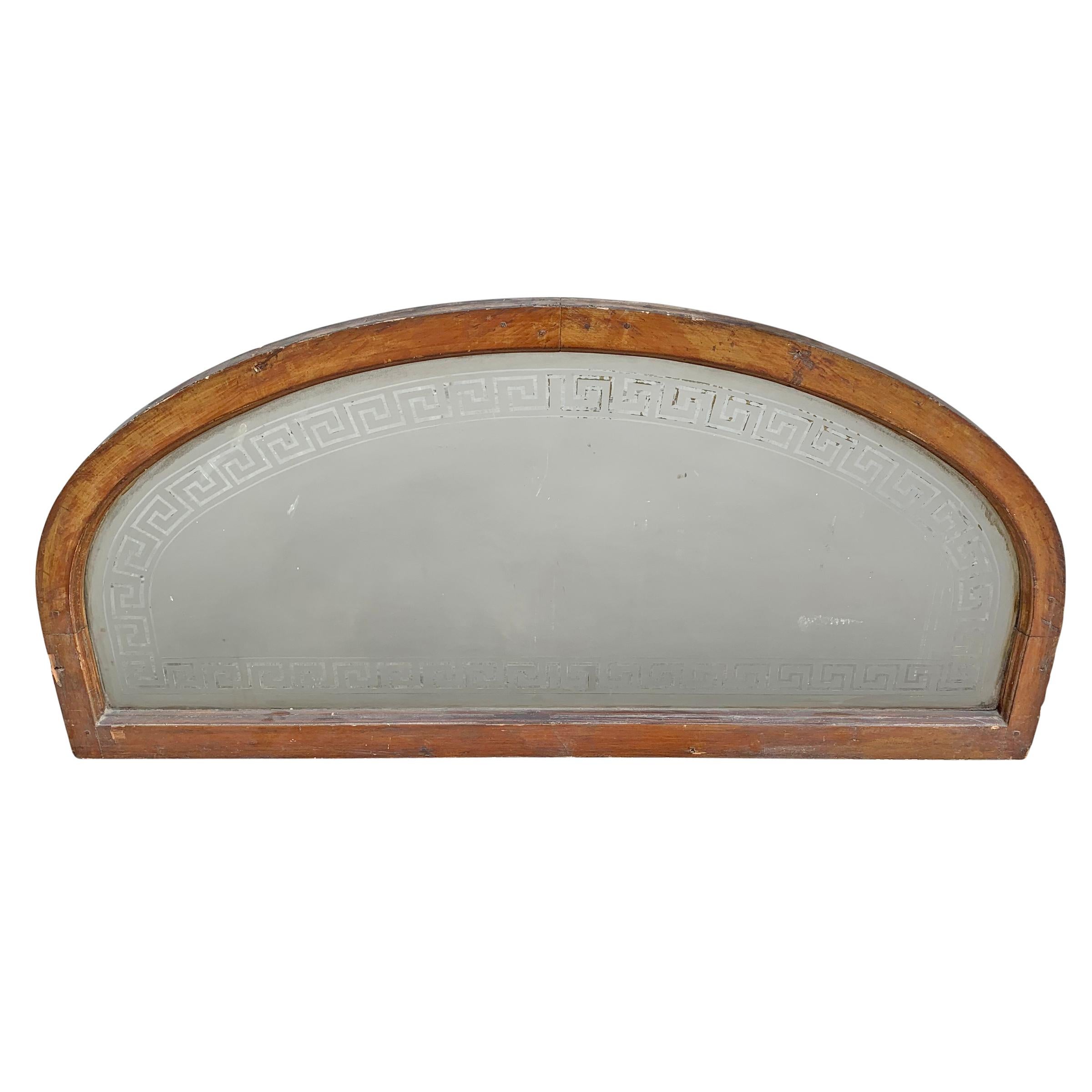 A marvellous late 19th century American arch top transom window with a hand-etched Greek key pattern framing a frosted central panel. It’s likely this was intended to be painted with the house number in the center, but it doesn’t appear to have even