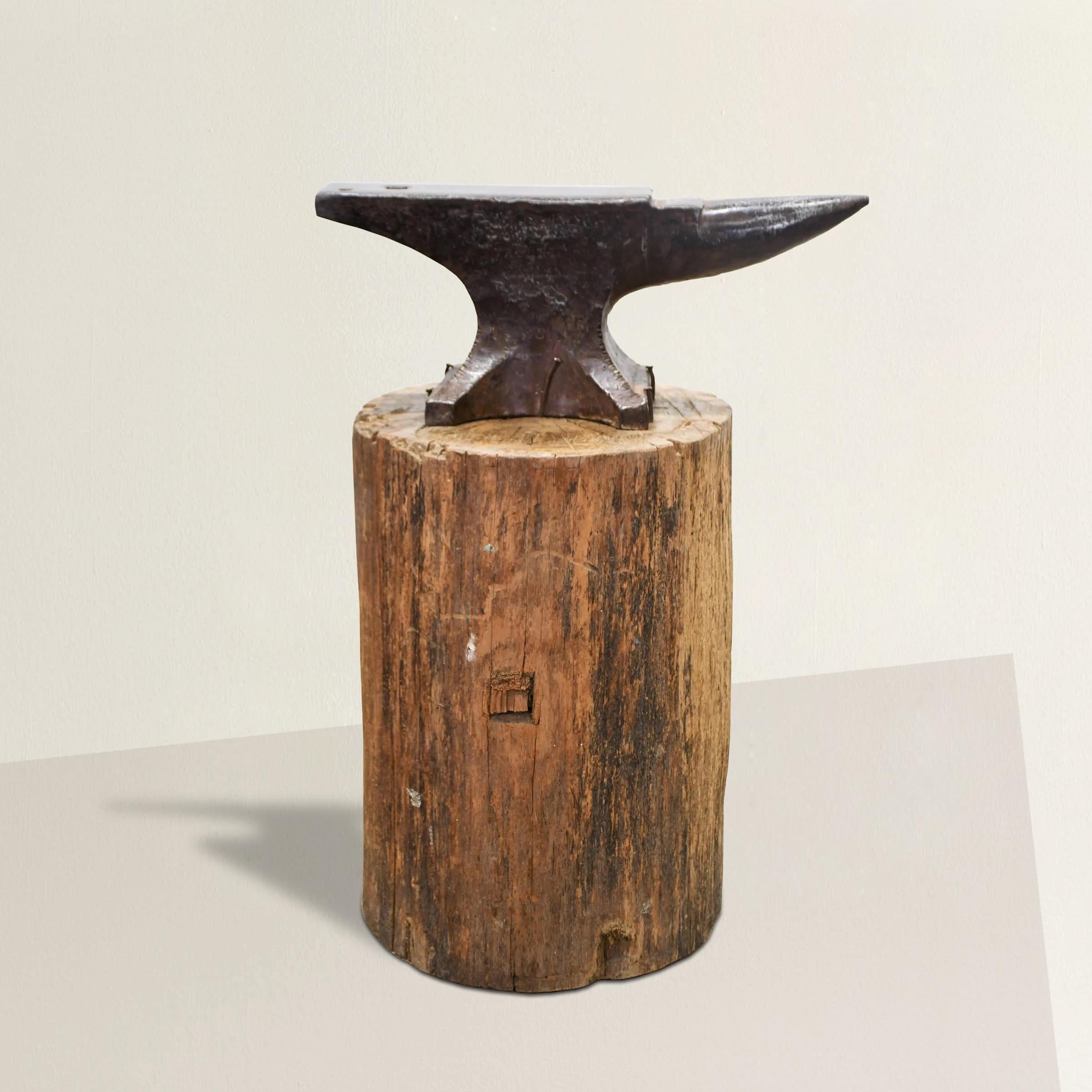 A striking 19th century American Blacksmith's iron anvil mounted with nails to it's original tree stump base. The anvil is attached to the stump with several hand-made nails. What a perfect piece of American folk art!
