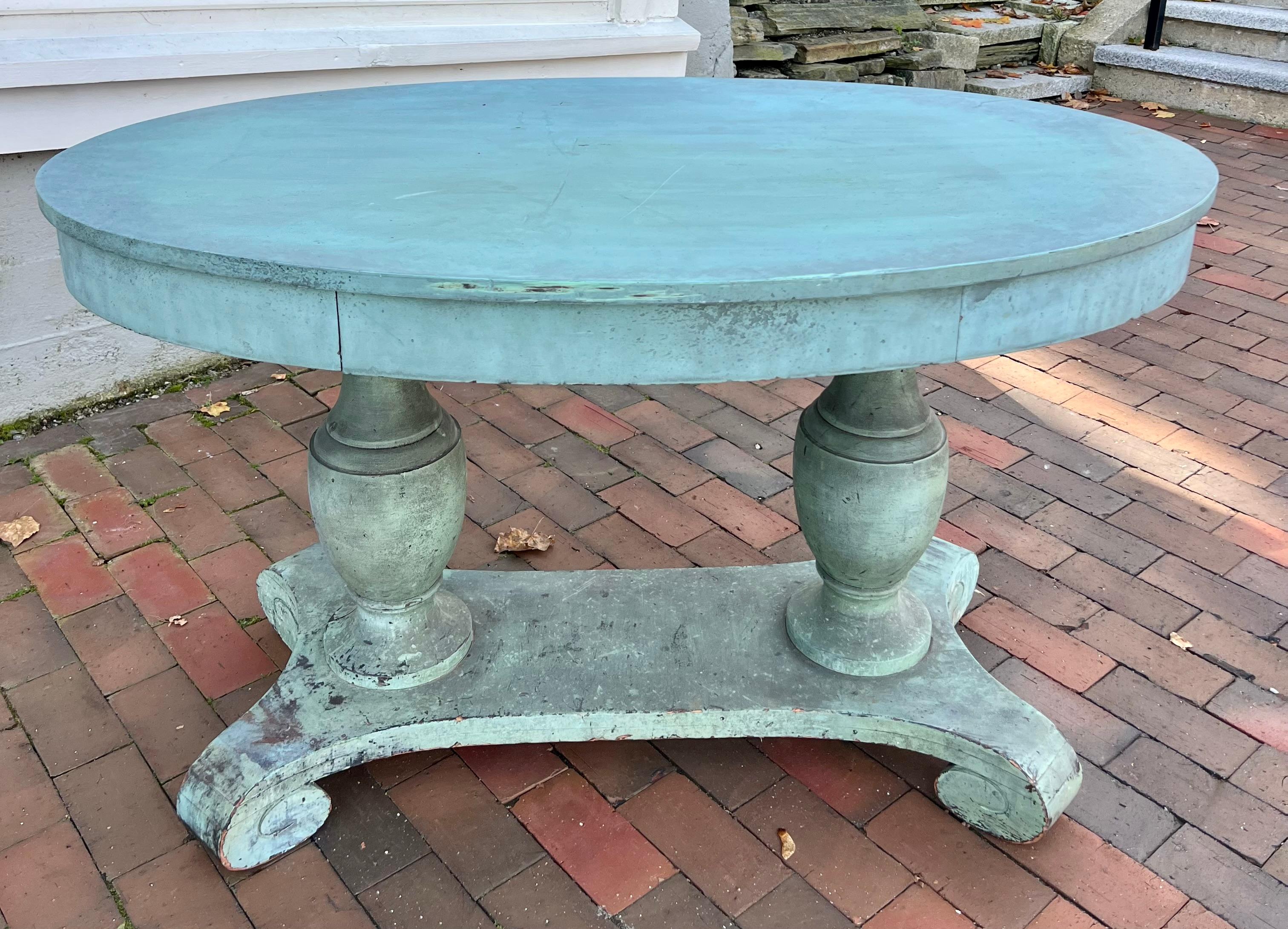 Early 19th century American table in fabulous early blue paint.  Featuring a pair of bulbous urn supports set on a stretcher base with scroll carved feet.  The color has a Swedish Gustavian feel to it and the size would allow it to be used in a