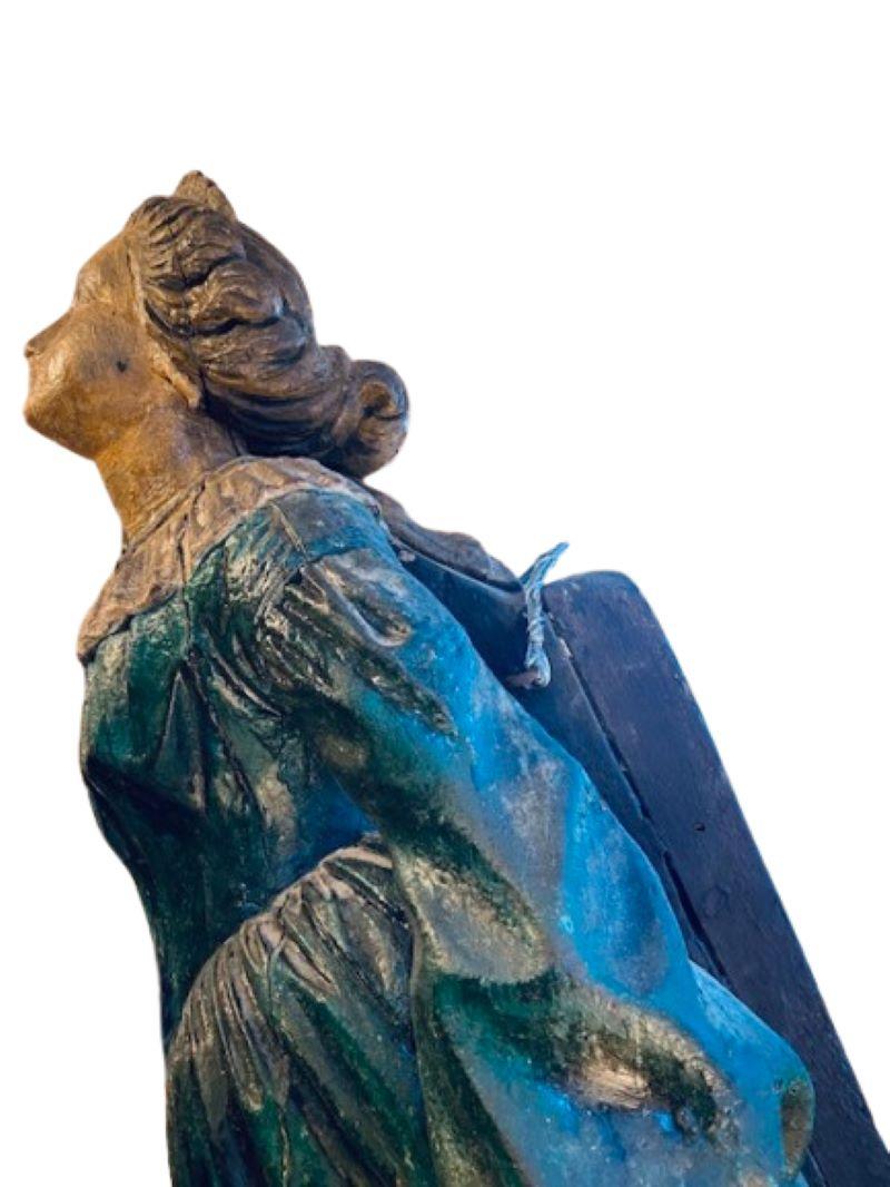 Figure de proue de navire américaine sculptée et décorée du XIXe siècle, vers 1880. Elle a la forme d'une élégante jeune femme aux traits ravissants et aux cheveux magnifiquement sculptés ramenés en chignon, portant une robe aigue-marine avec un col