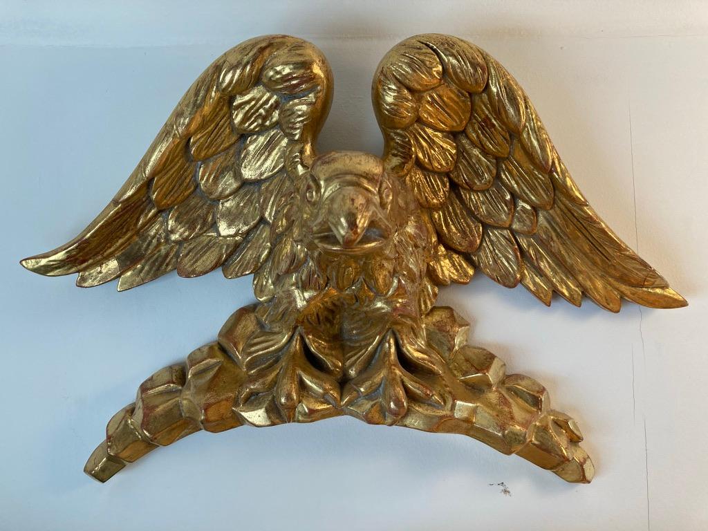 Beautifully carved circa 1810 giltwood eagle. According to family legend, this was originally the crest of a bullseye mirror that was damaged and then lost. The gilding is in wonderful condition, there is a one inch section on the tip of one wing