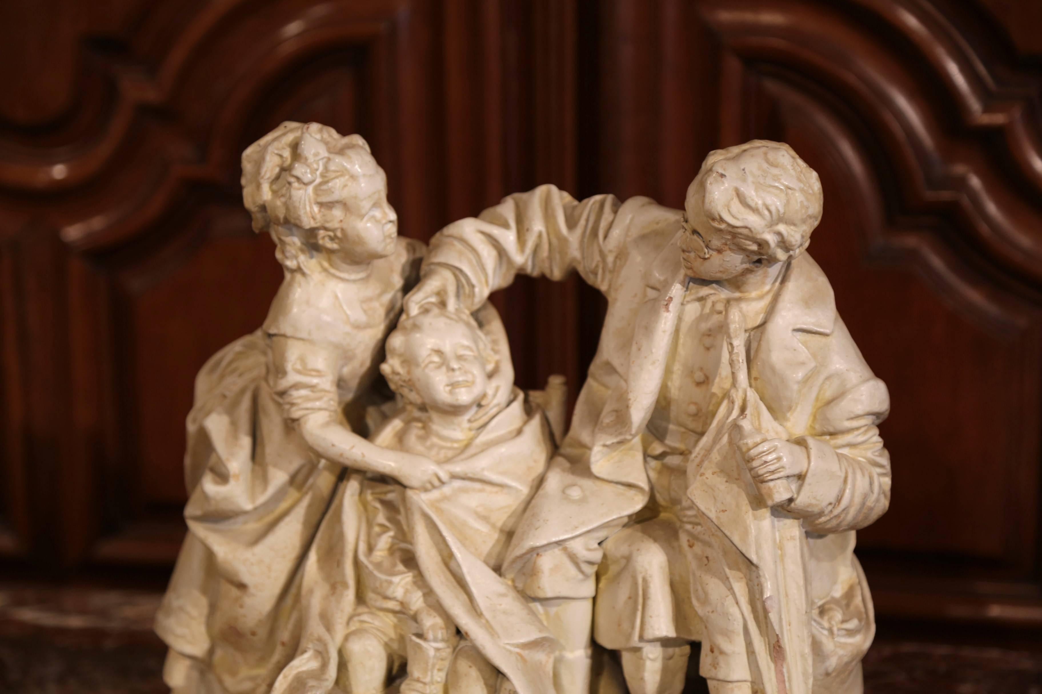 This beautiful, terracotta sculpture was sculpted in New York, circa 1880. The patinated cast plaster piece features three children playing doctor, nurse and patient. The work of art is titled on the front 