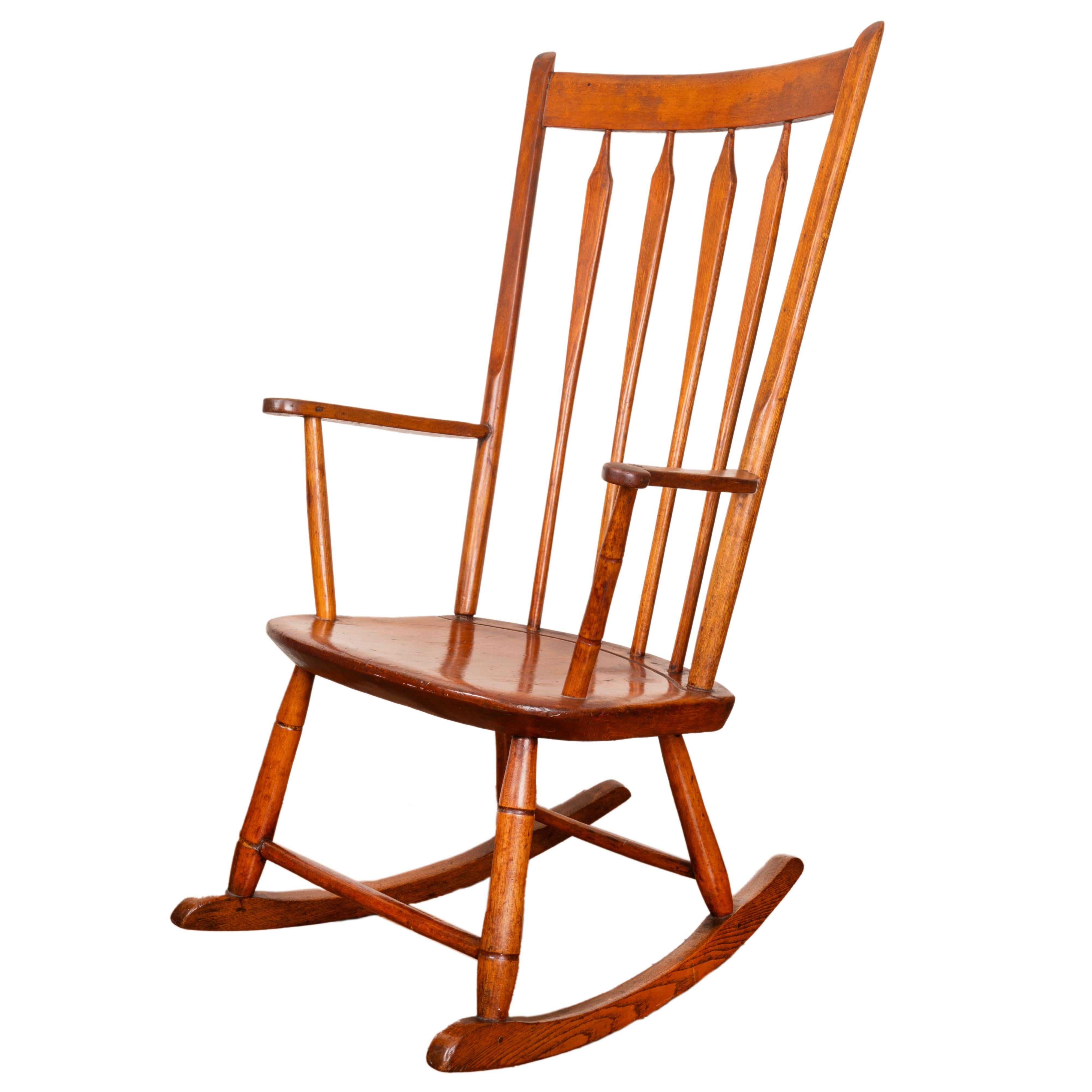 Beautiful solid cherrywood 19th century American rocking chair with high slat, four-arrow back rest, below solid crest rail, flanked by short arm supports, with knuckle terminals, the solid shaped seat raised on turned legs and rocking device.

-38